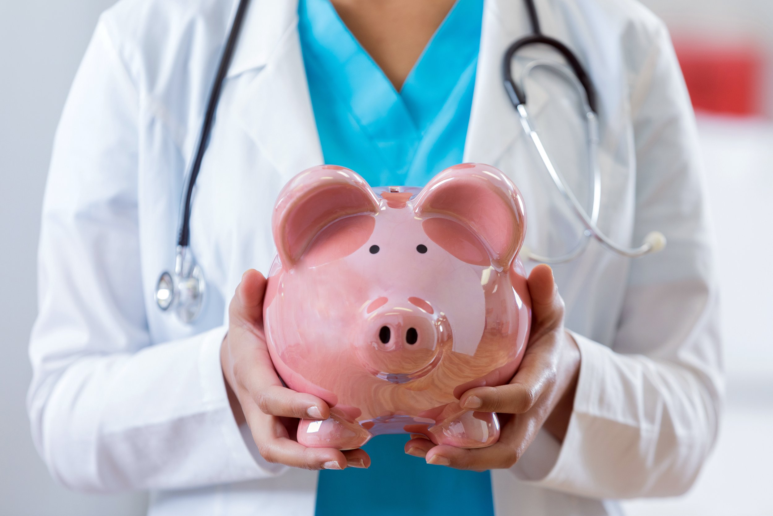 Health care professional holding a piggy bank