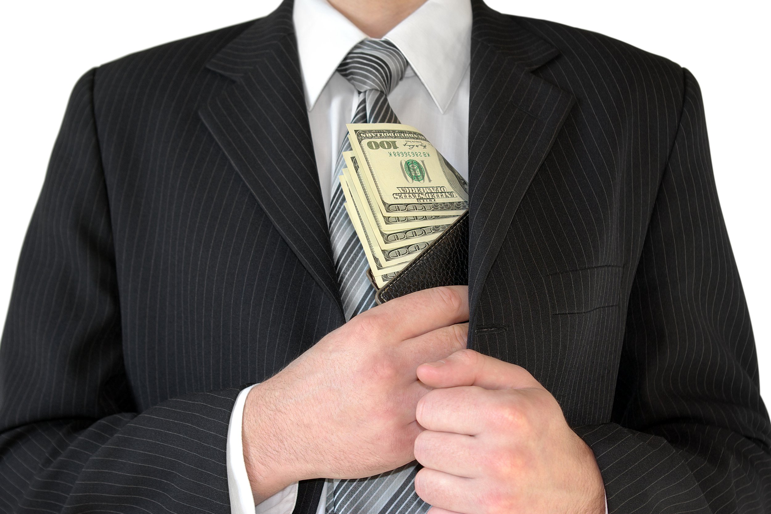 Man wearing suit putting cash in his coat pocket