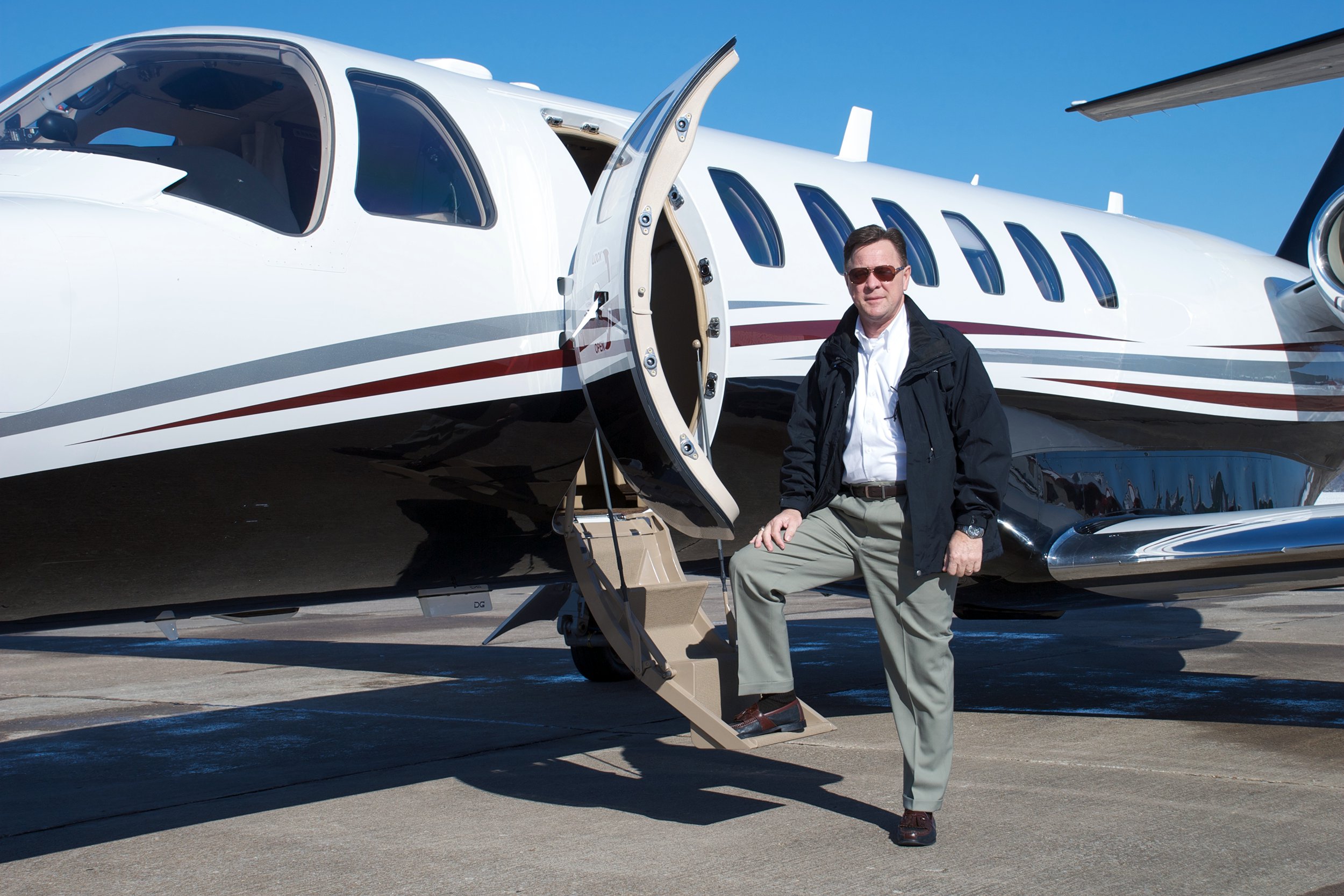 Man standing on the stairs of his private jet