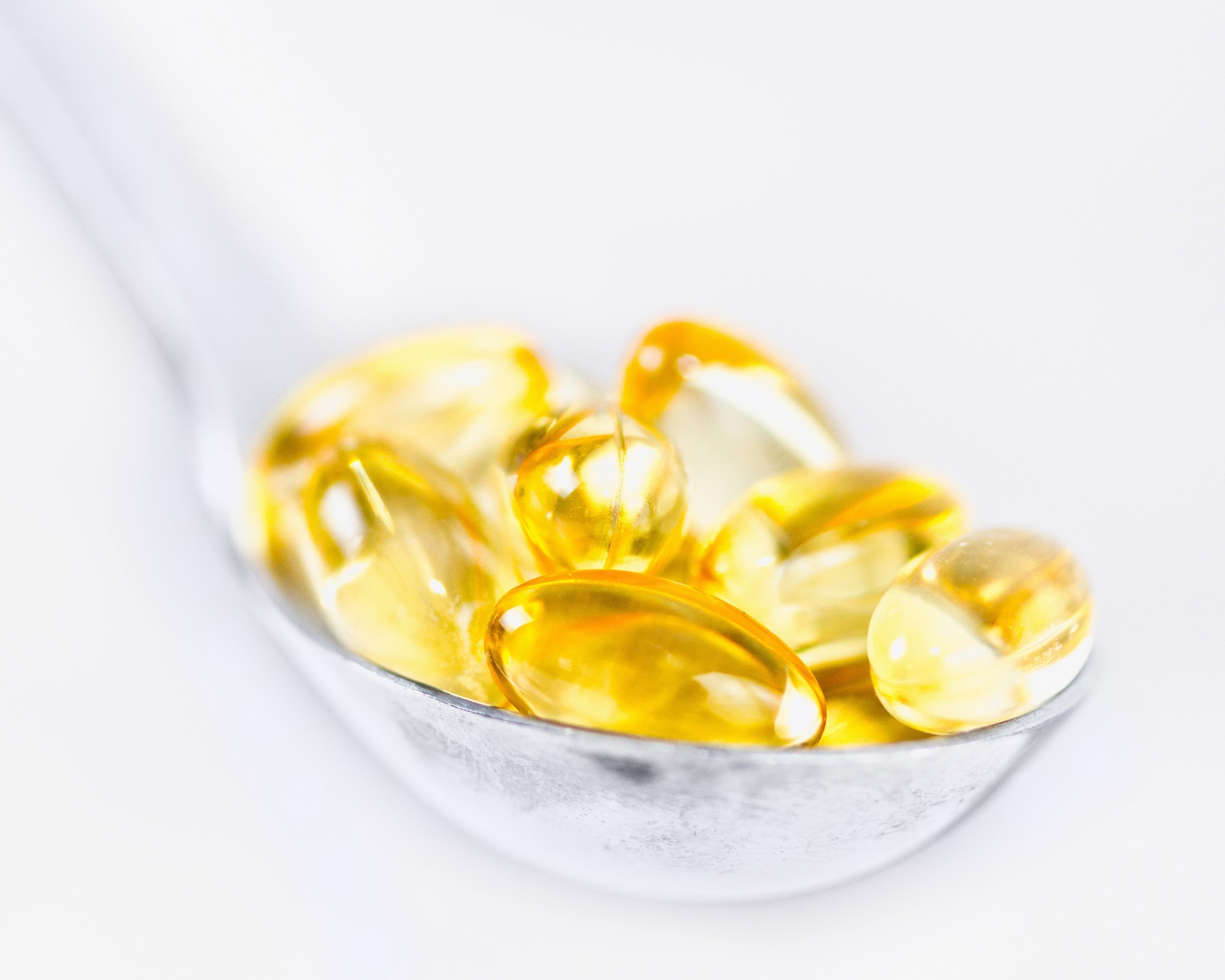 vitamin E softgels in a spoon