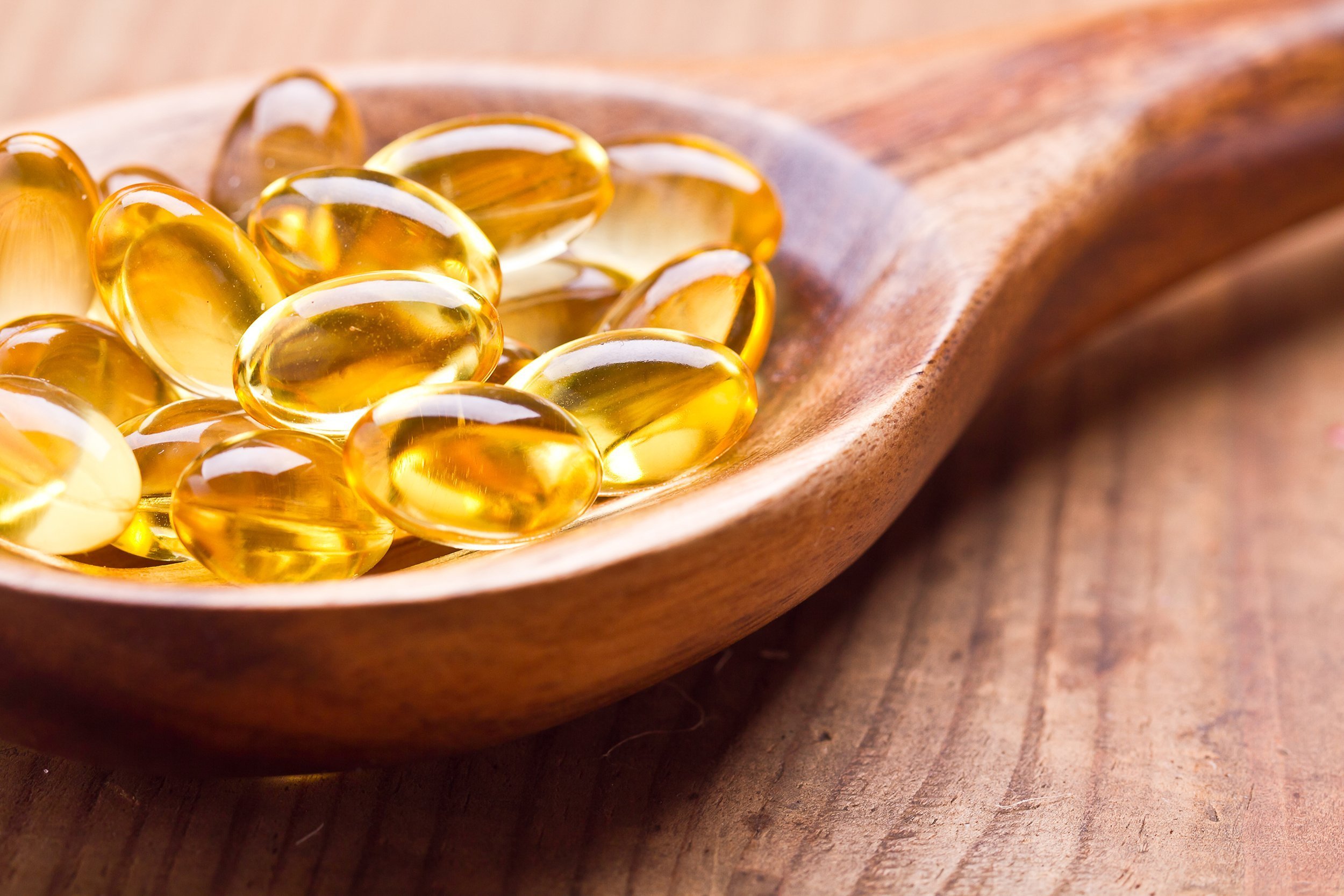 fish oil capsules in a spoon