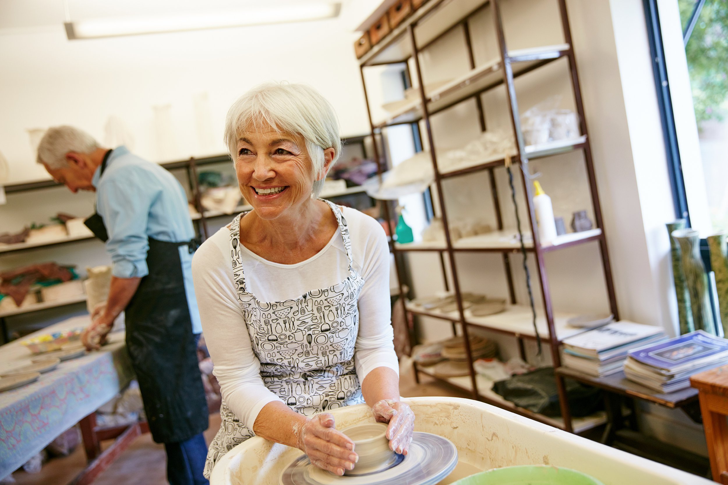 Senior woman taking a pottery class with her husband