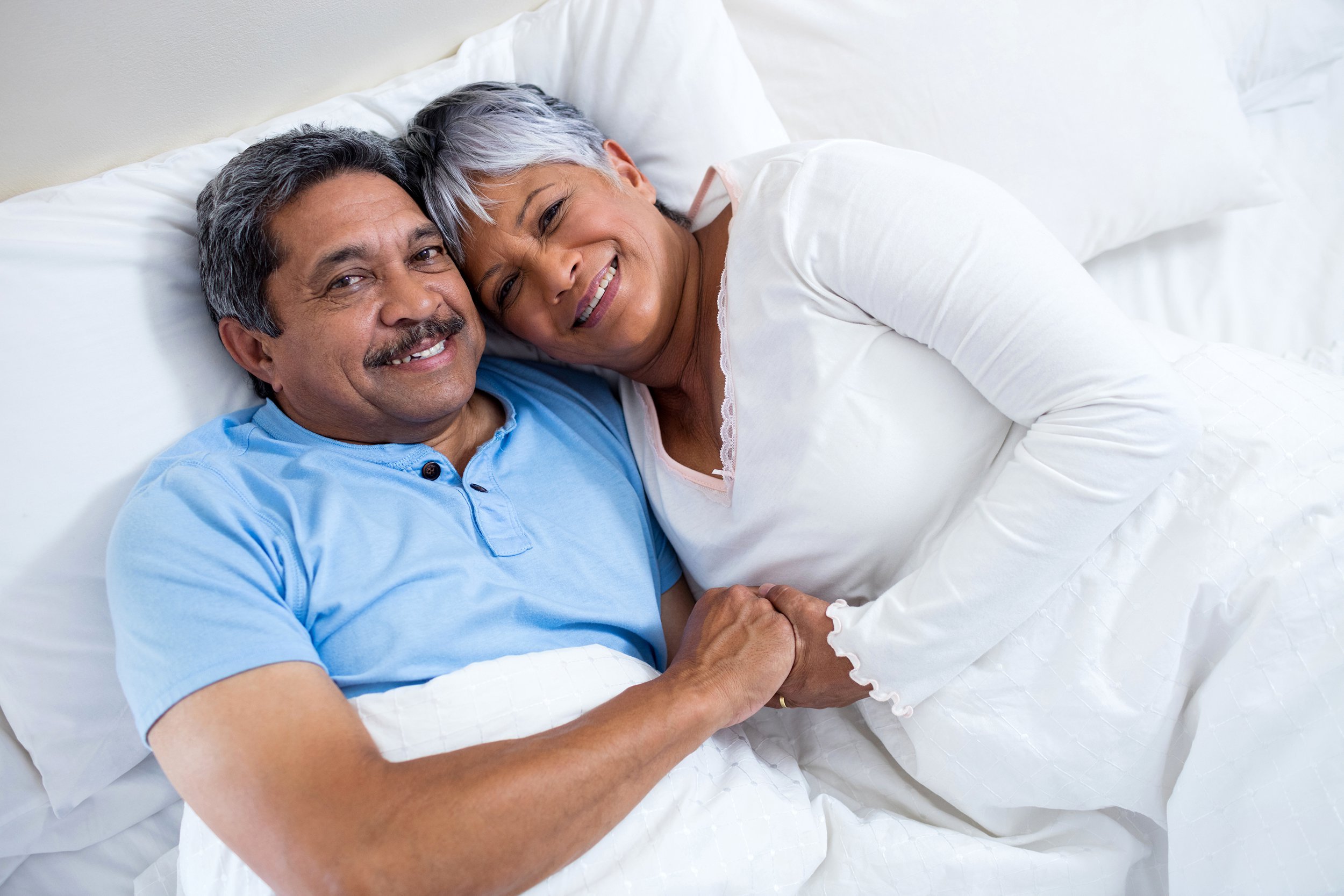 Happy couple relaxing in bed