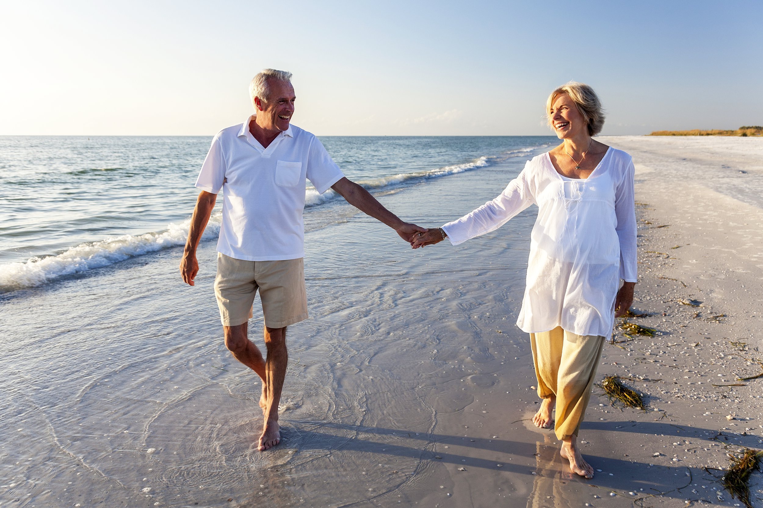 Senior couple walking together on the beach