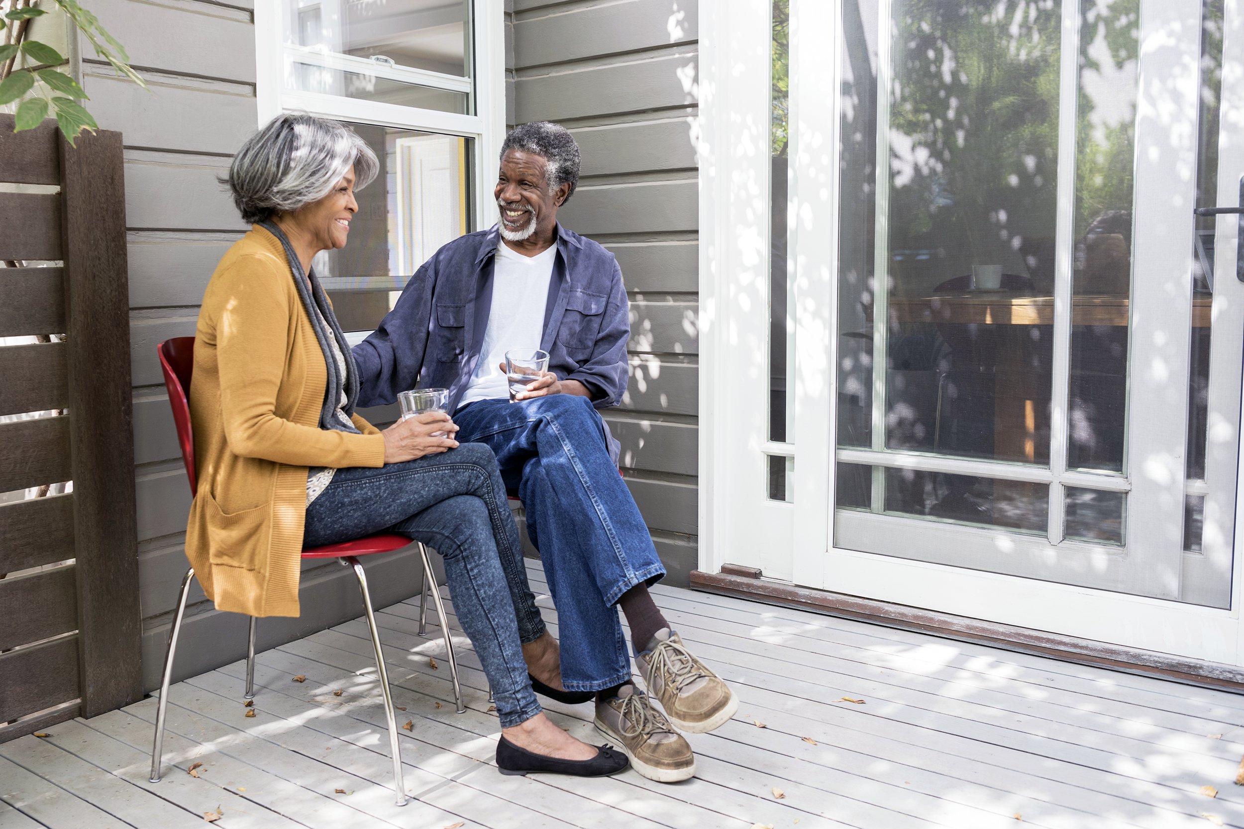 Senior couple sitting on their porch having a conversation