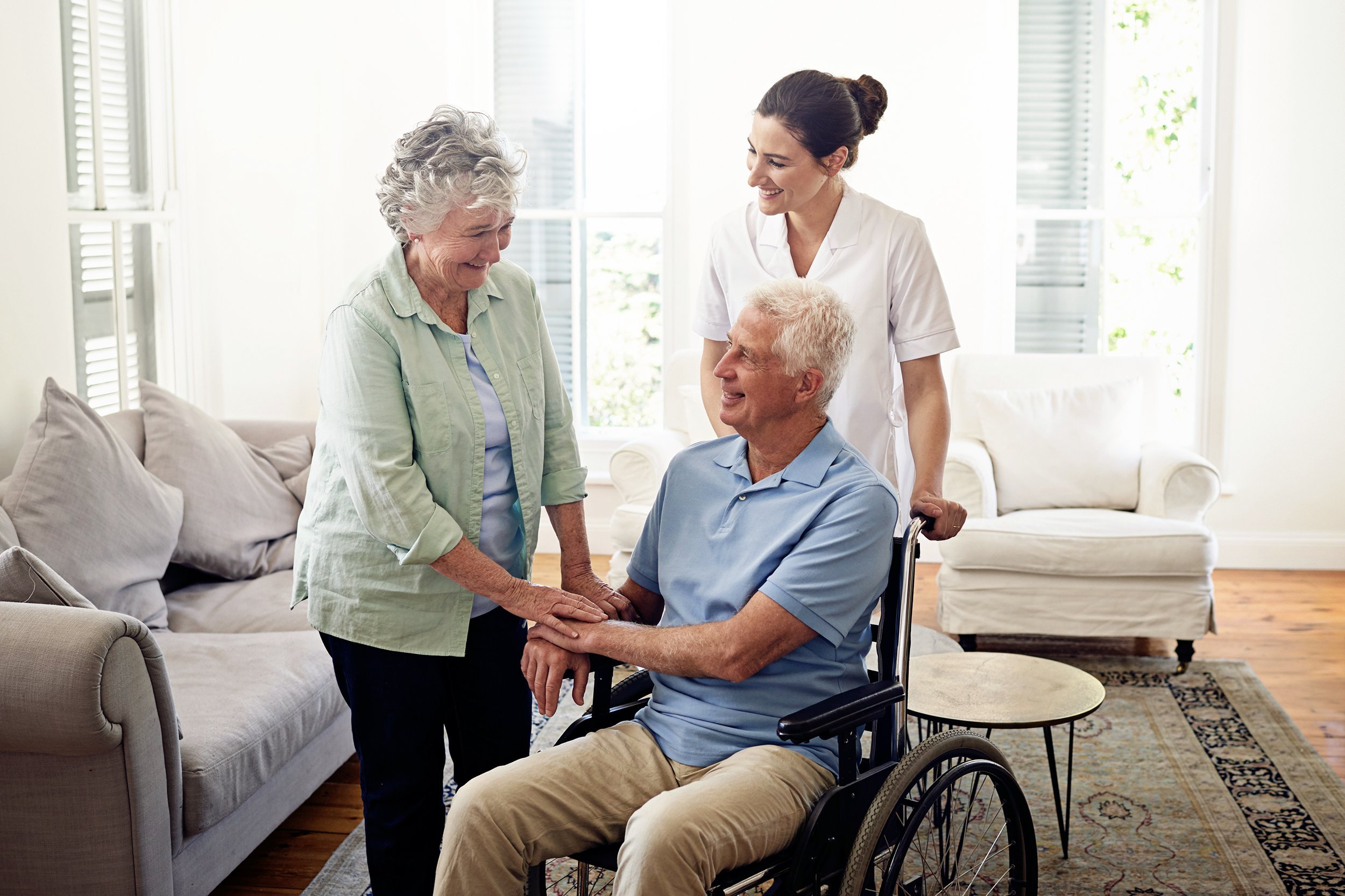 Senior man in a wheelchair next to his wife and caregiver