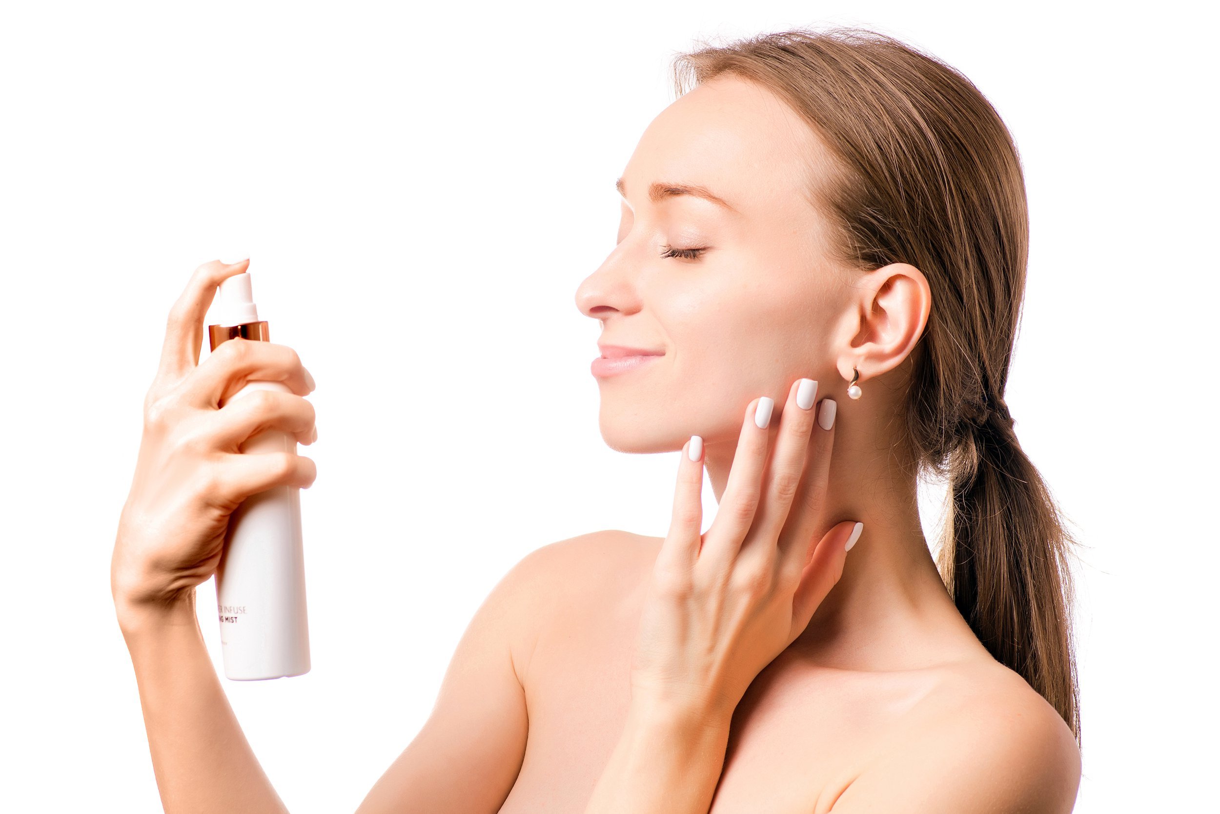 Woman spraying facial mist on her face