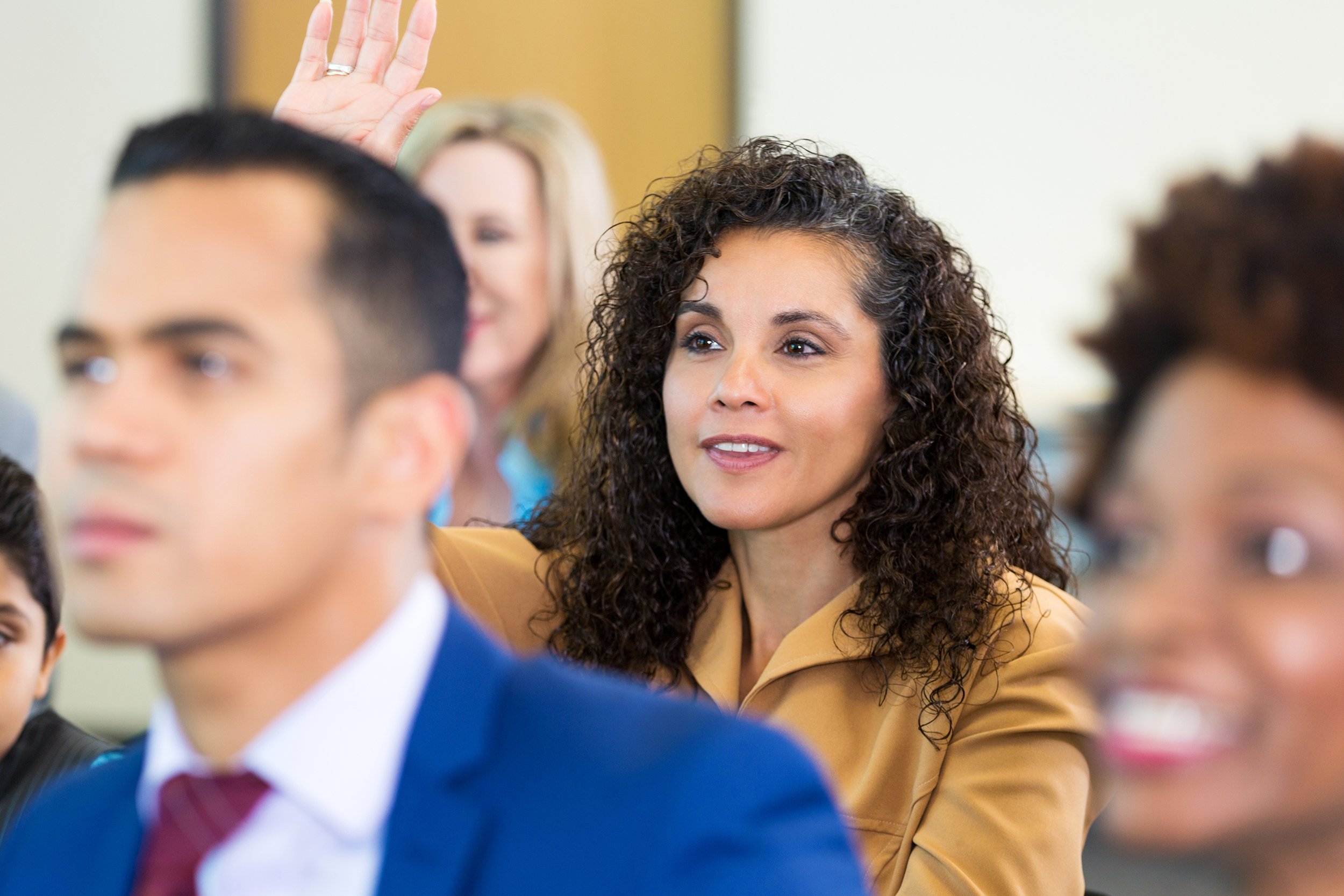 Woman raising hand at a meeting
