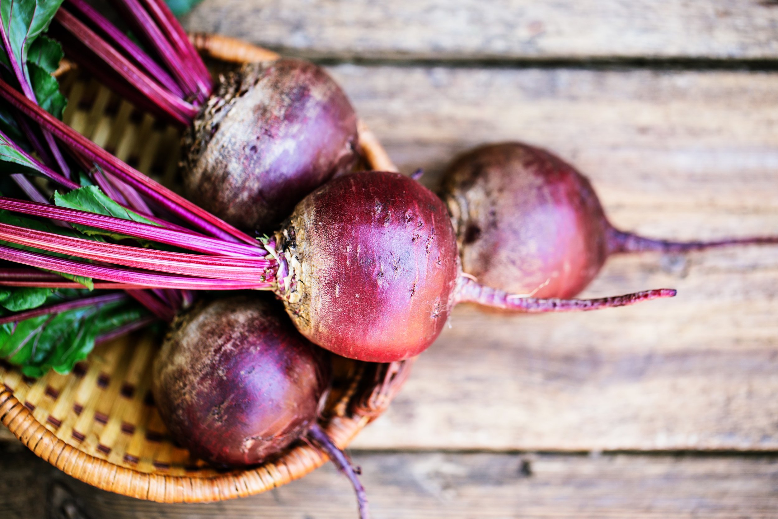 beets in wicker basket on wooden table