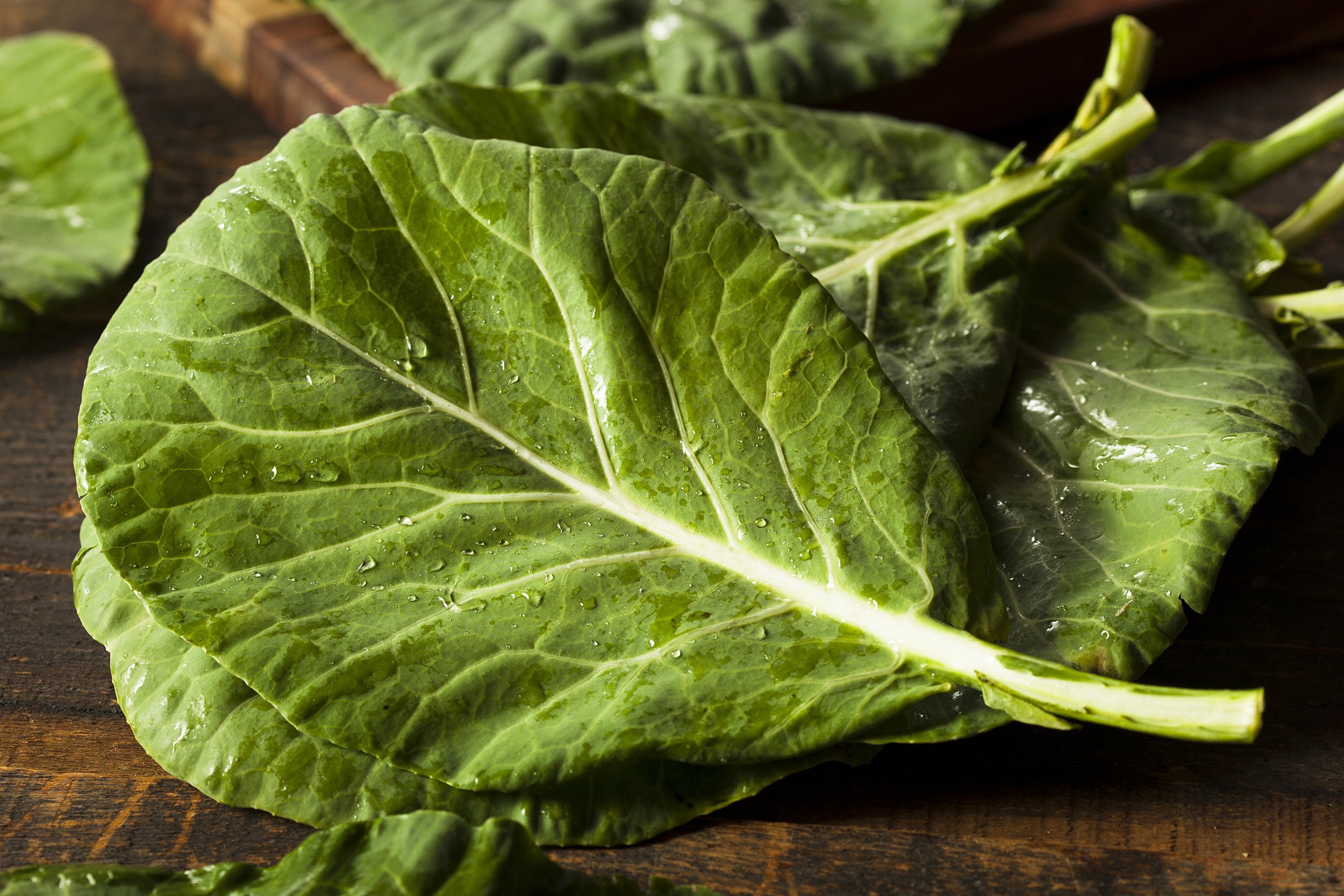 green collard Greens on wooden table