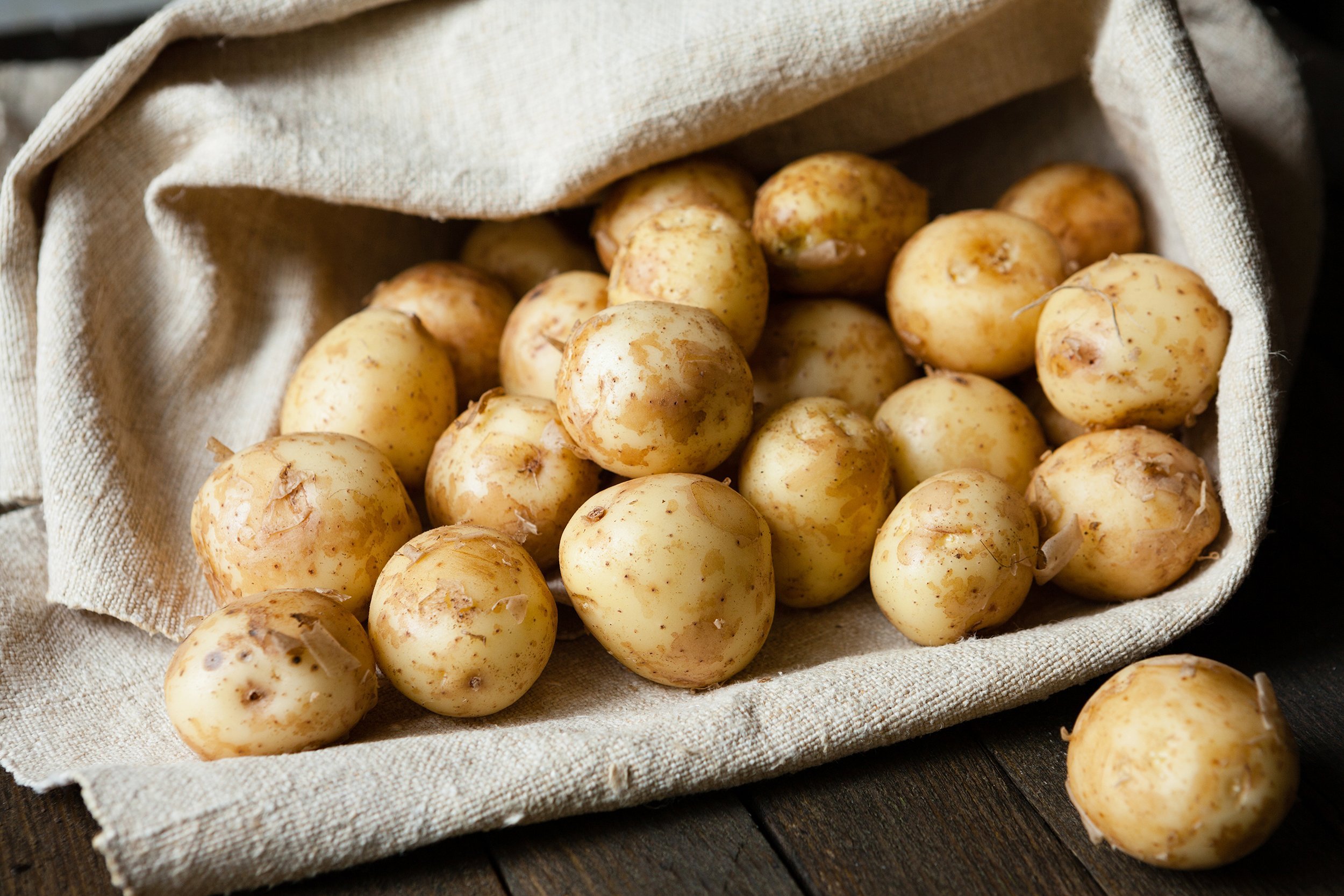 new potatoes with the peel on the table in a bag