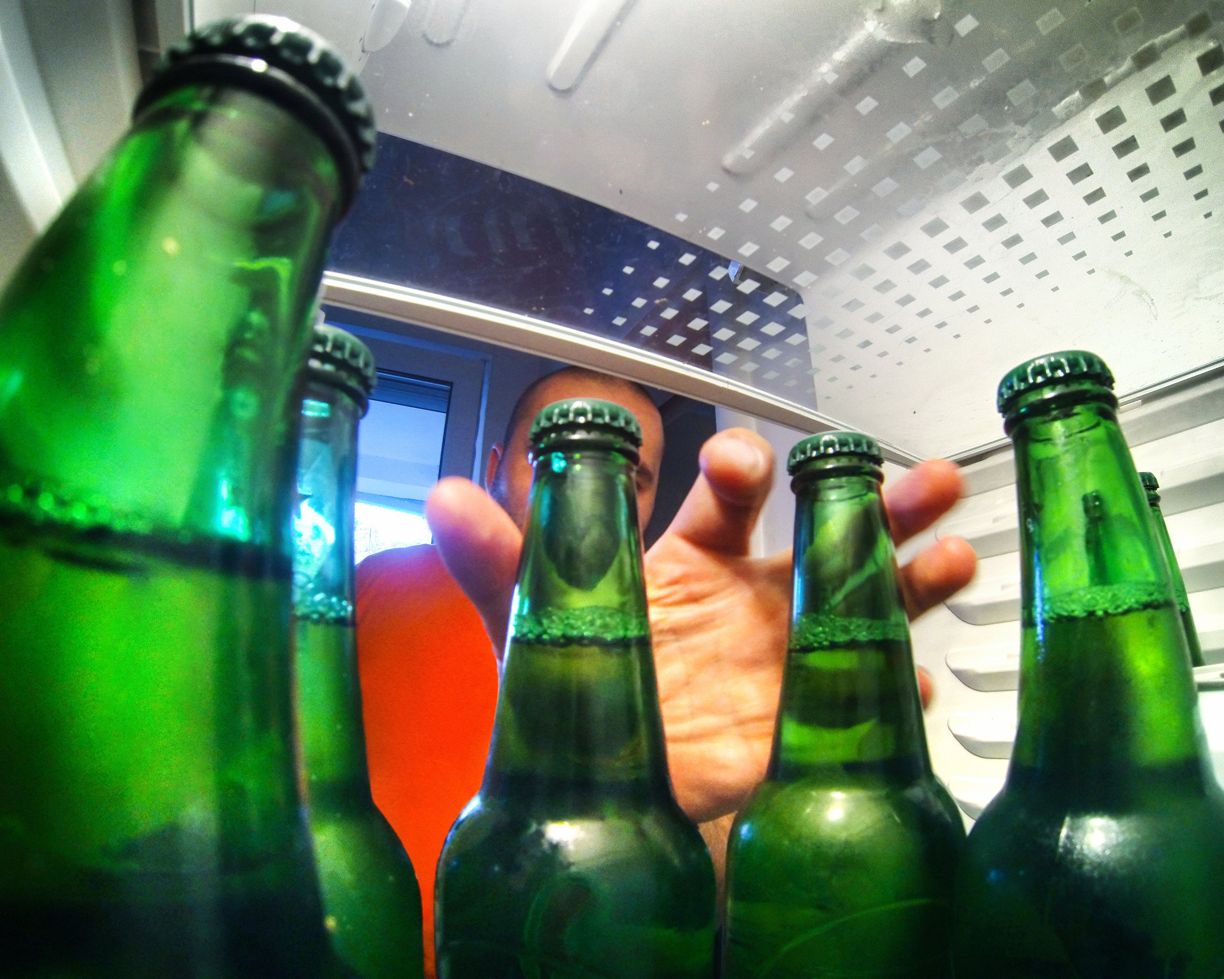 man taking beer out of fridge