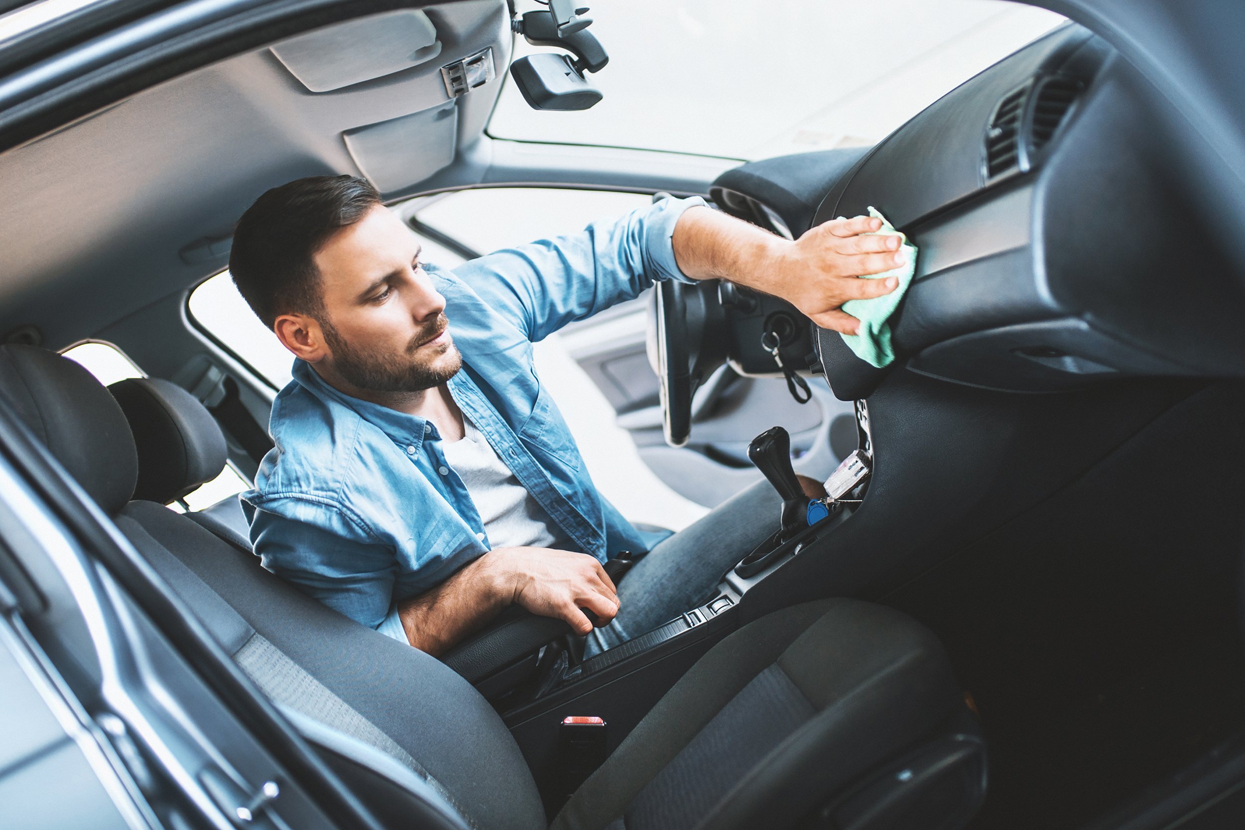 man cleaning interior of car