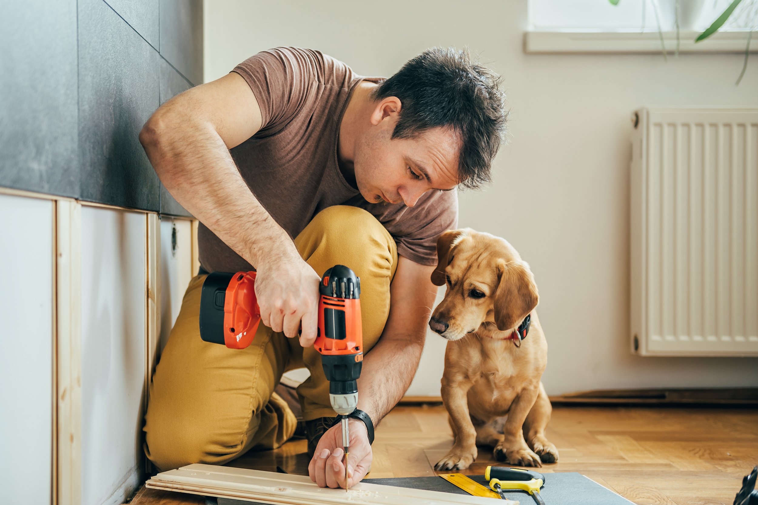 man using drill in home