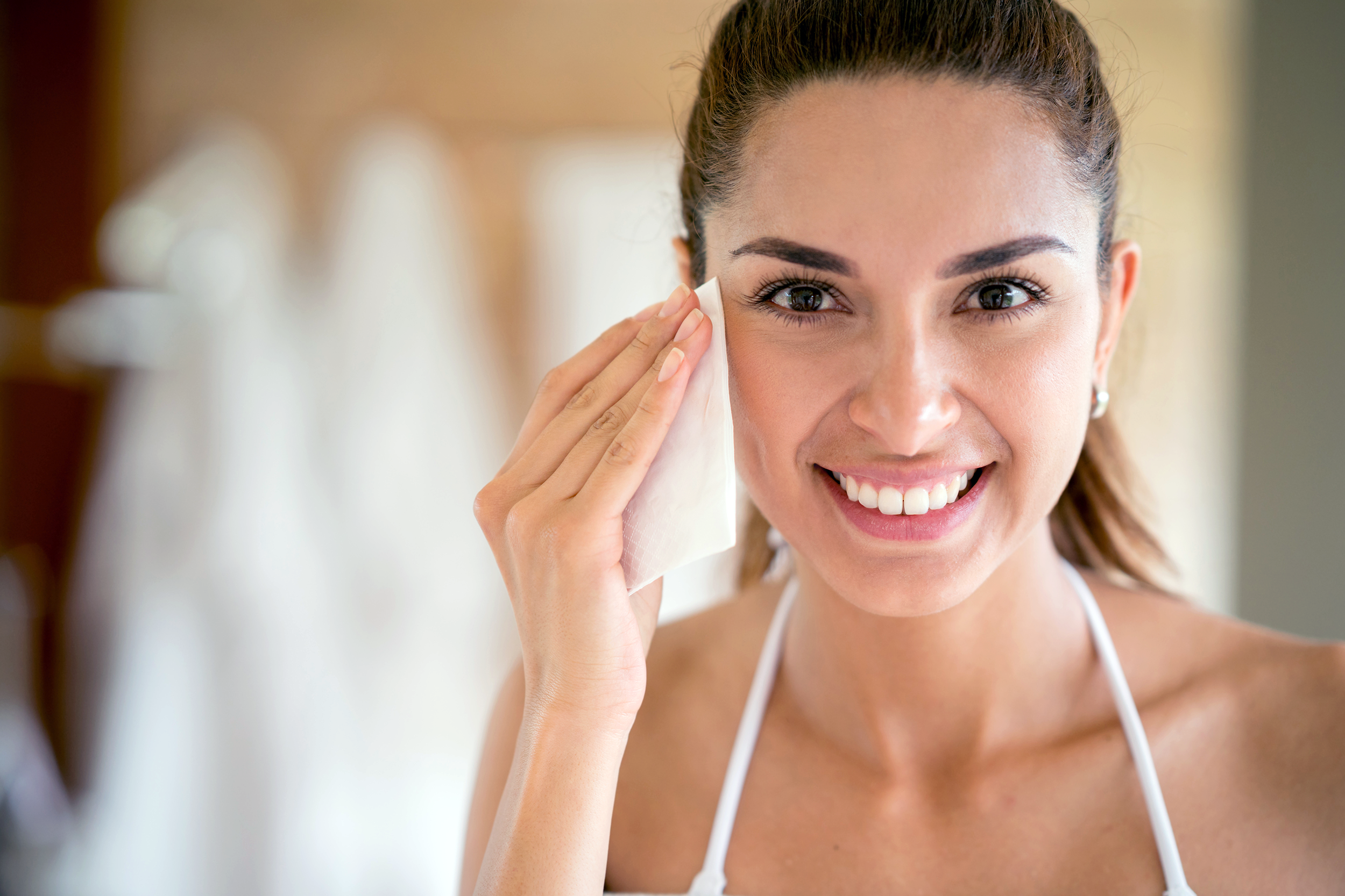 Woman cleaning face with a wipe