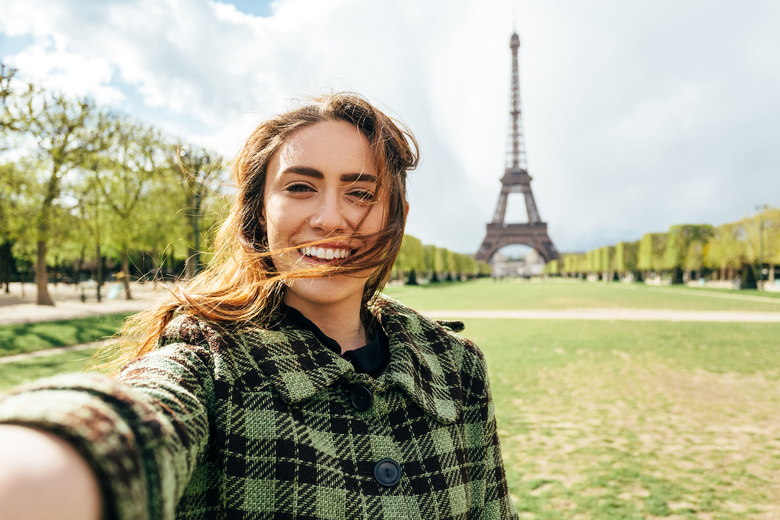 Woman taking selfie with Eiffel Tower in the background