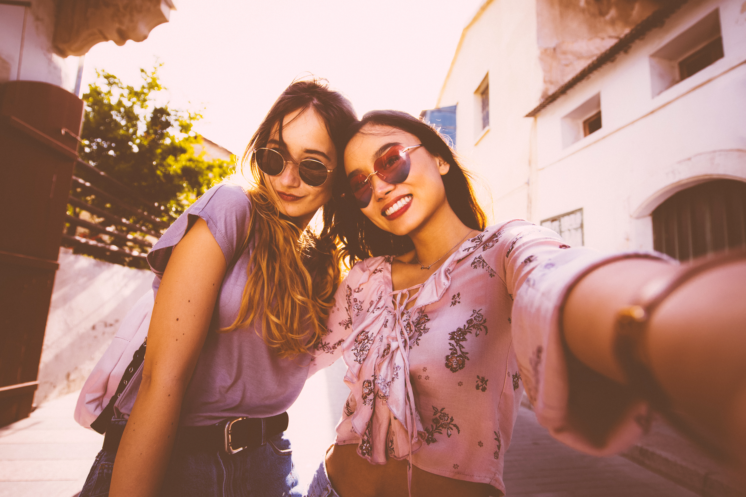 Selfie photo of two girls with a pink filter
