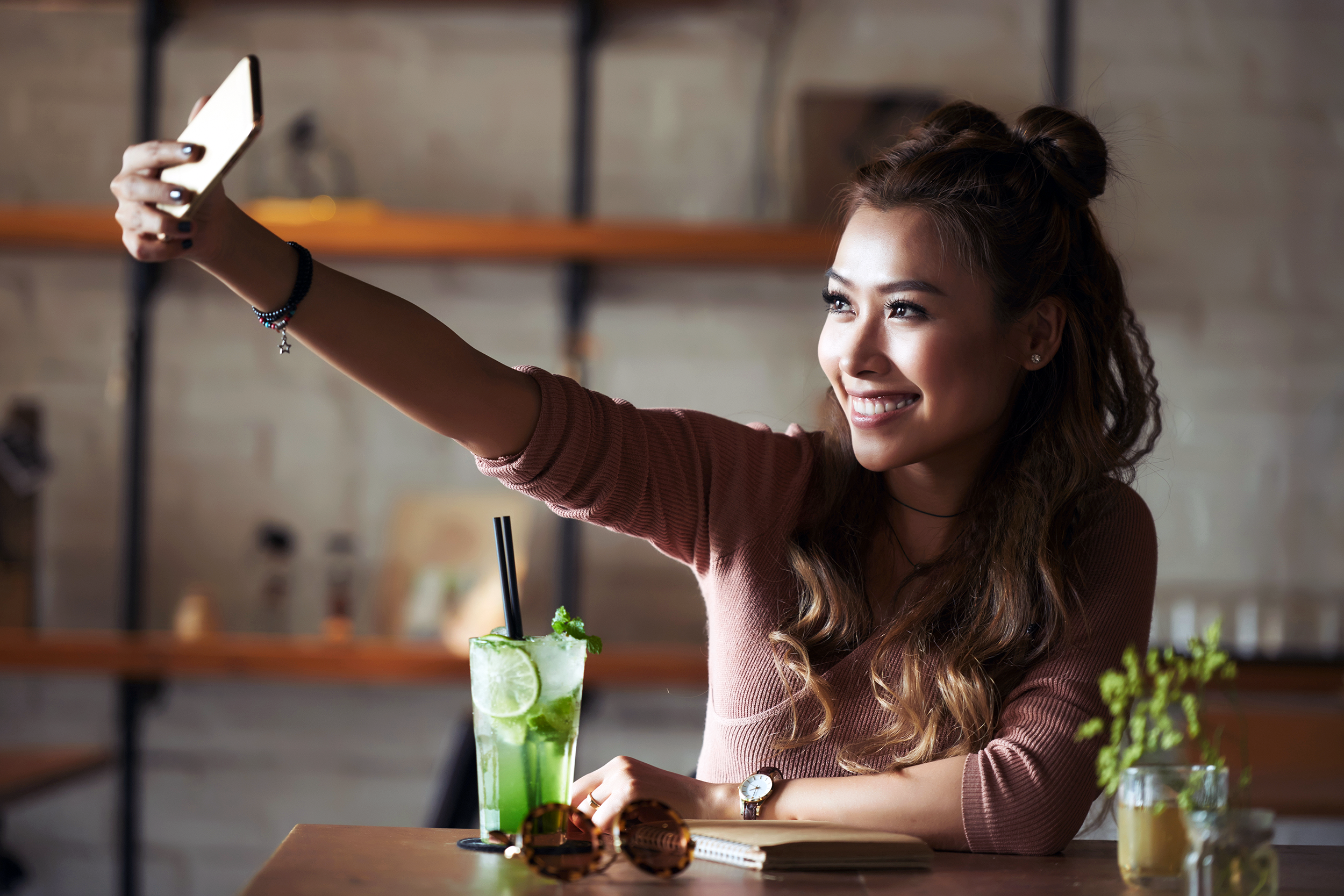 Woman taking selfie in kitchen with natural window light