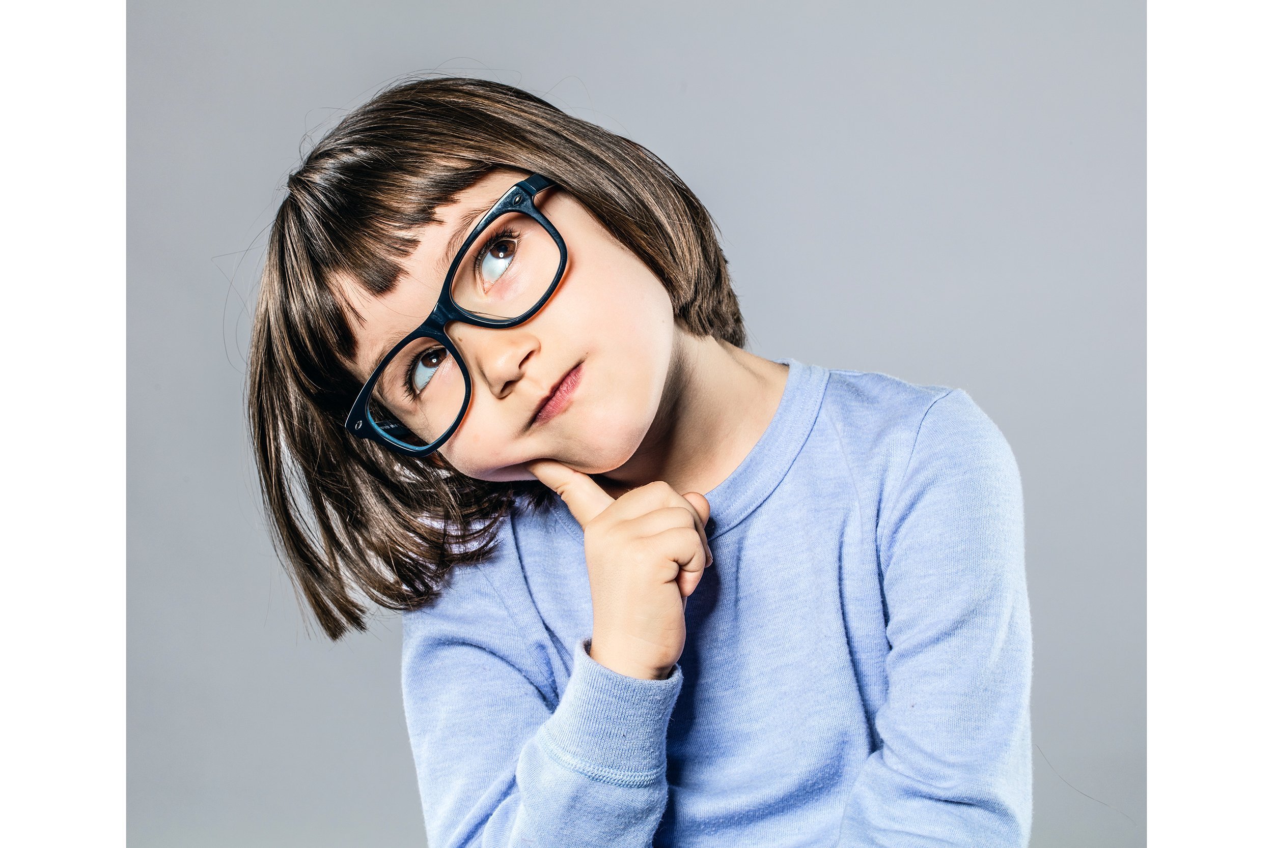 Little girl with glasses looking puzzled or thoughtful