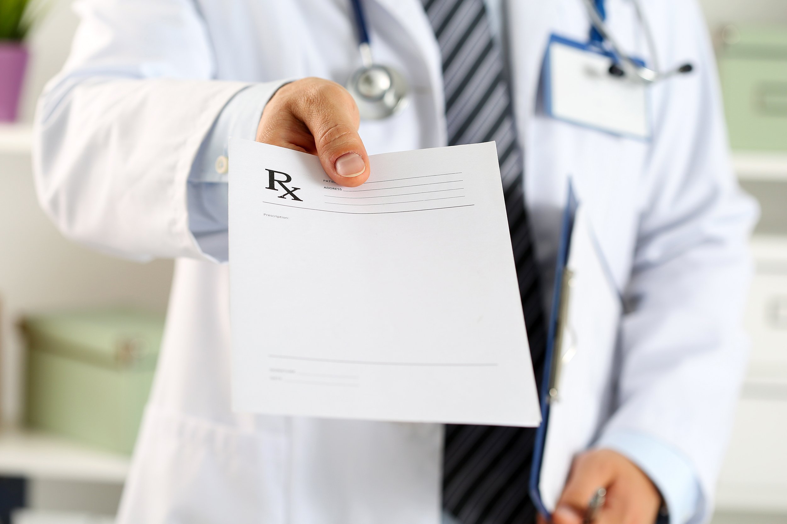 Doctor handing a prescription on a piece of paper