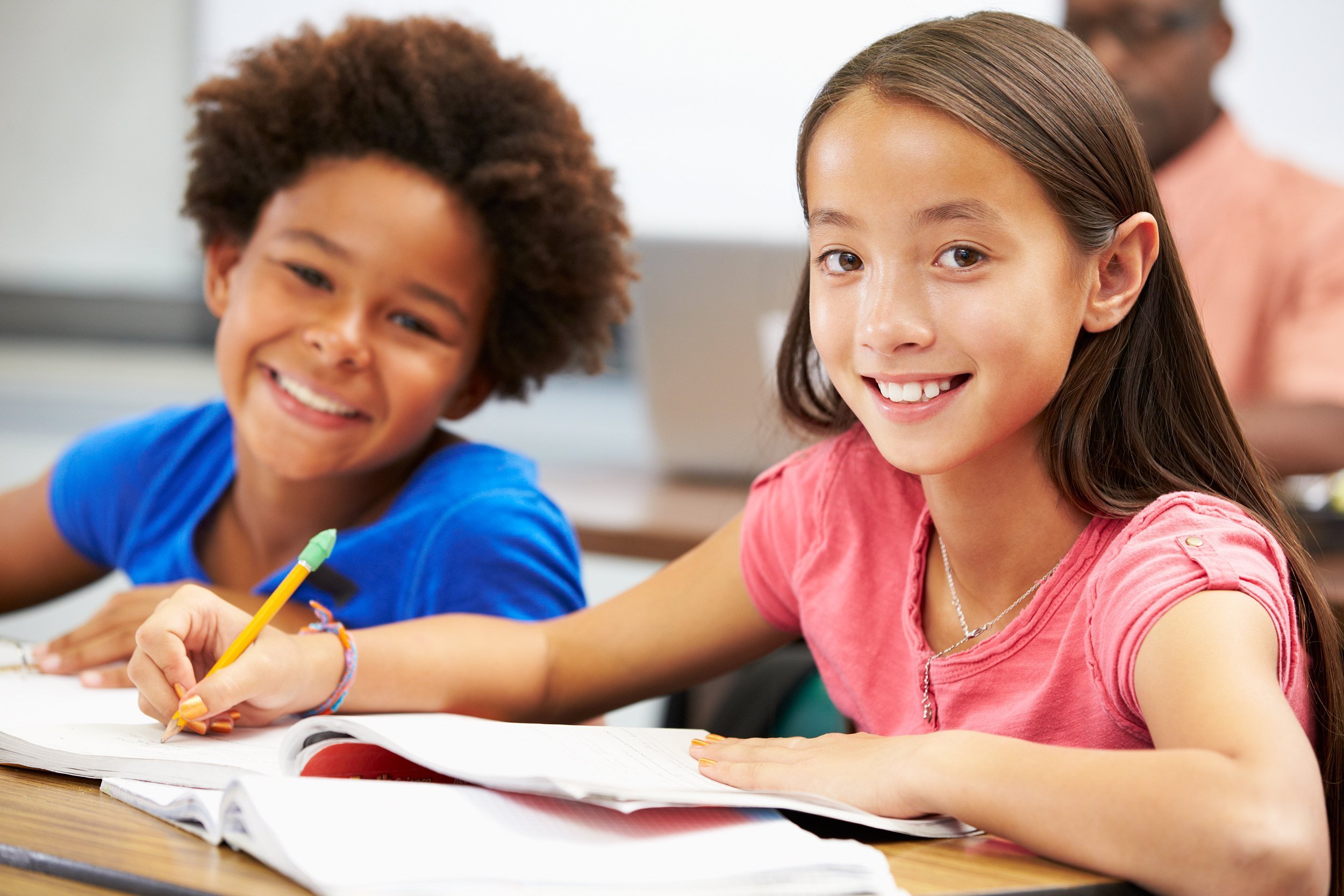 Two elementary school girls sitting at their desks
