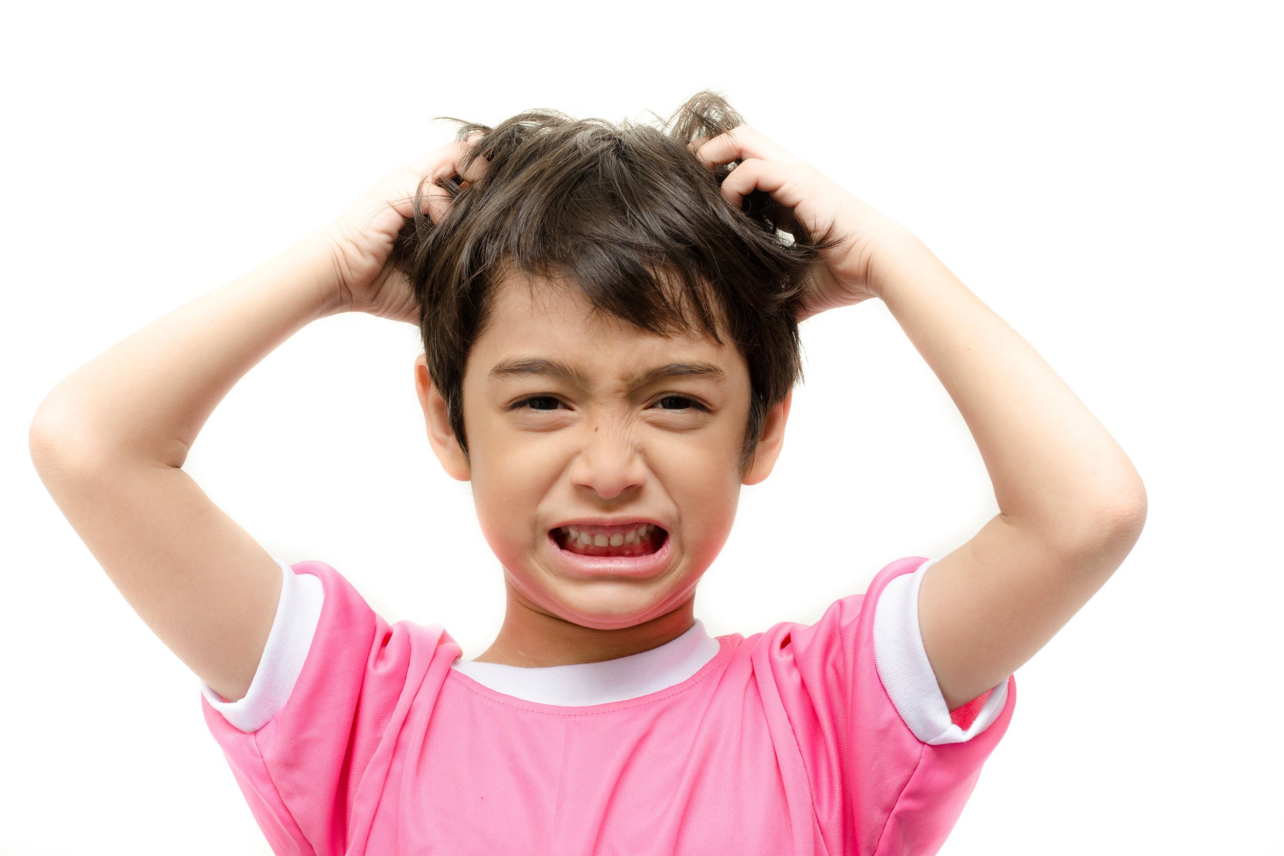 Young boy annoyed and scratching his head from lice