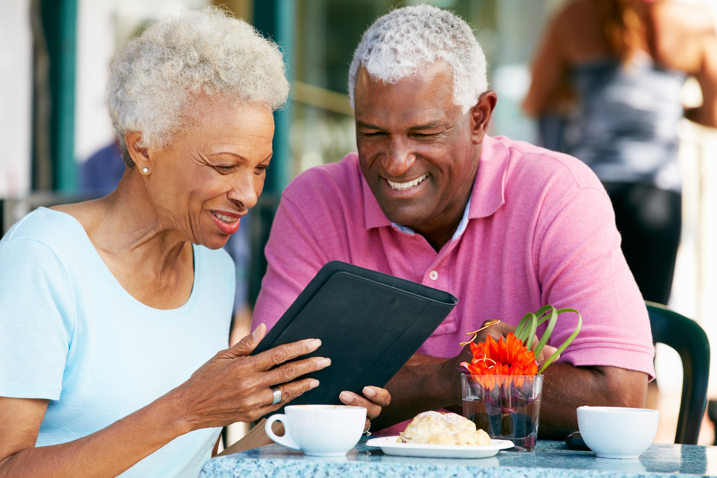 African American couple looking at tablet in a cafe