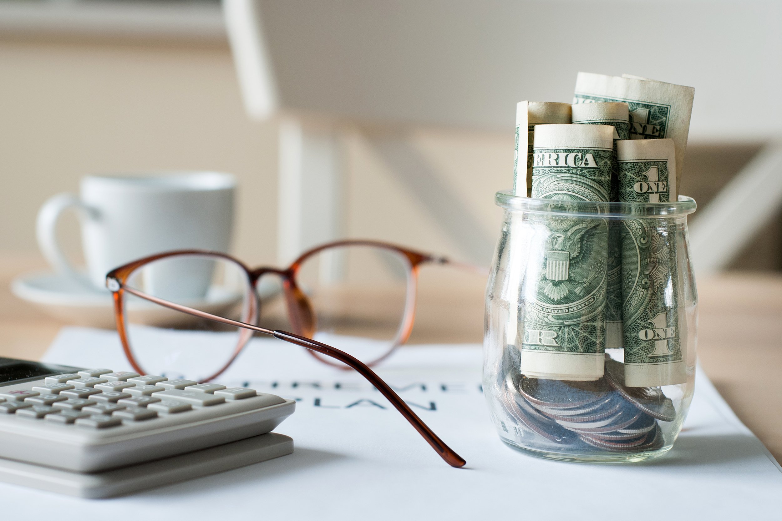 Retirement savings plan concept with dollars in a glass