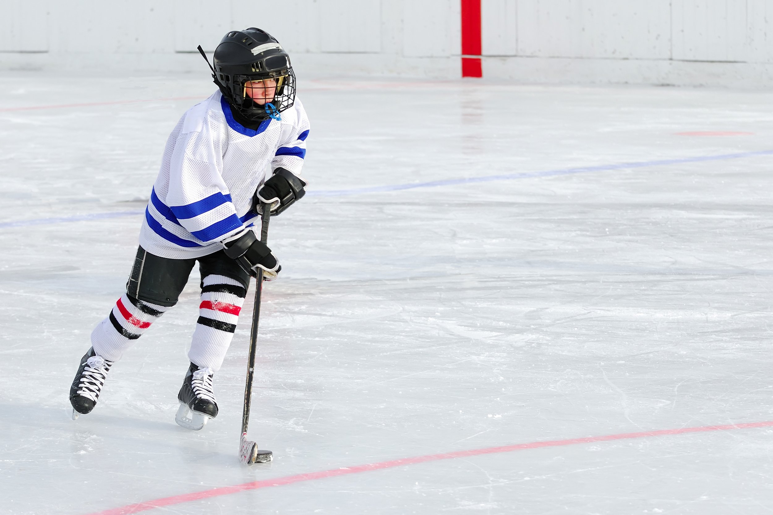 kid ice hockey player with the puck