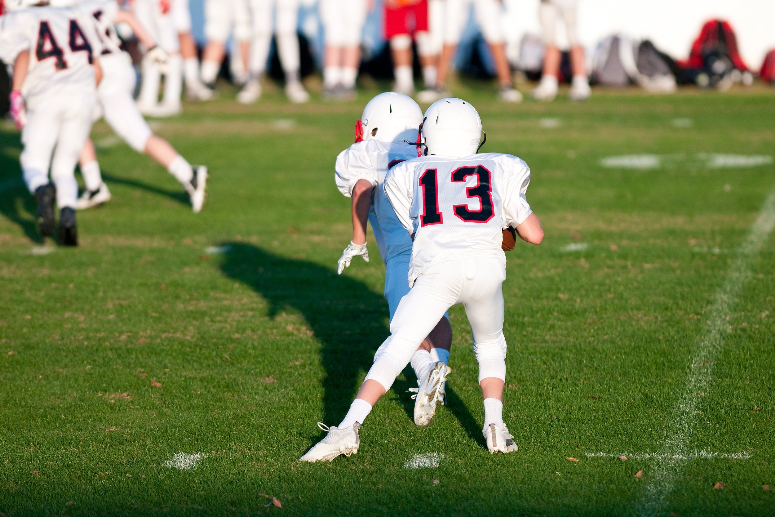 kid quarterback and football players during a game