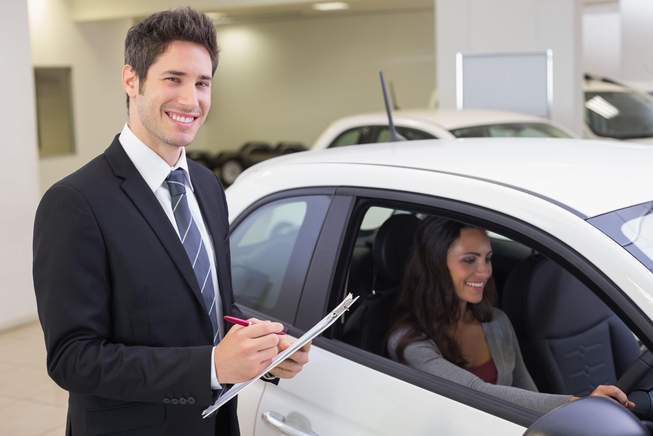 car salesperson selling car to customers