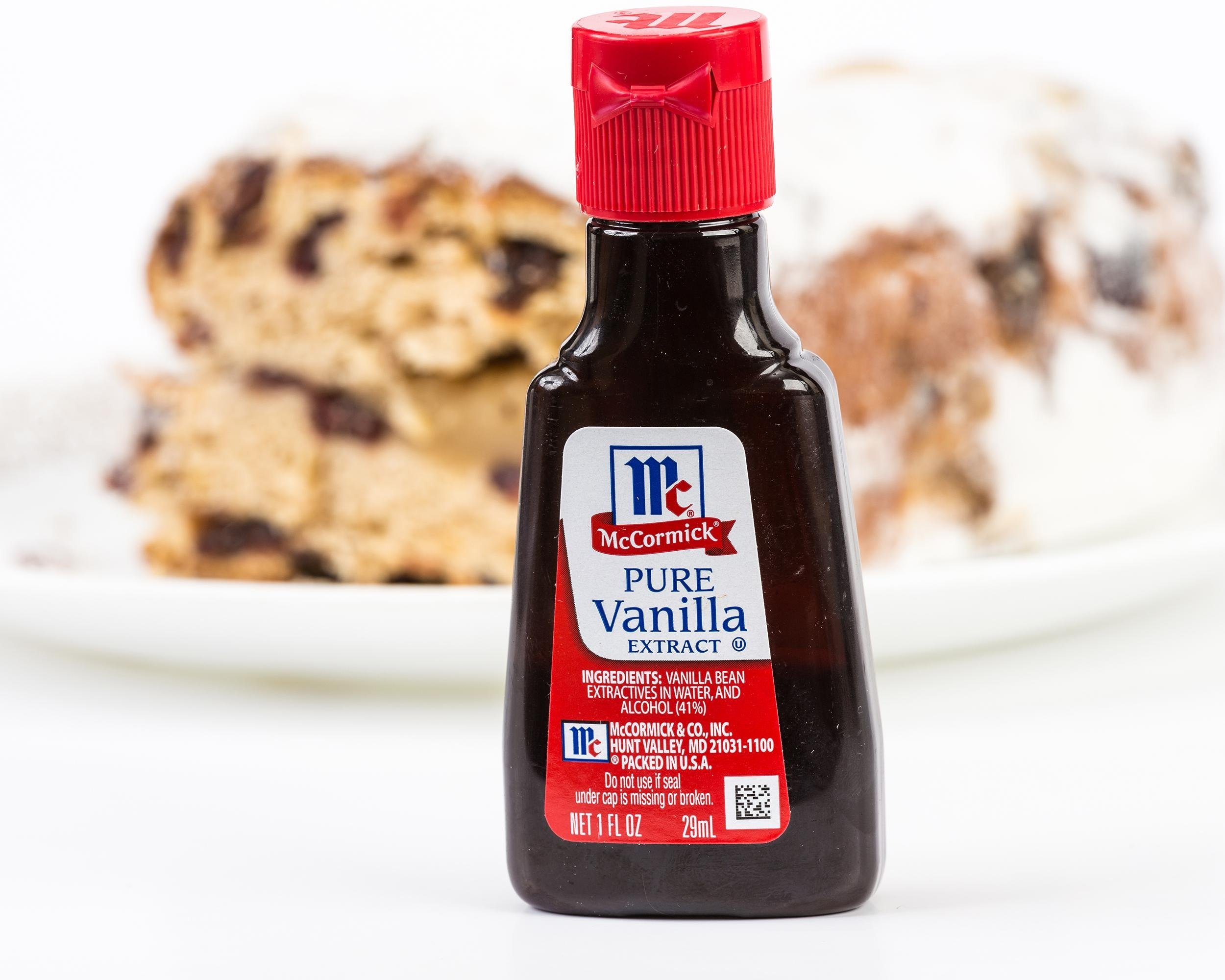 small bottle of McCormick Pure Vanilla Extract with baked cake in background