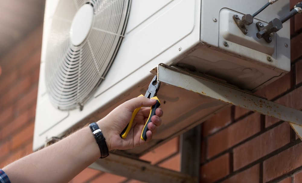 male technician installing outdoor air conditioning unit