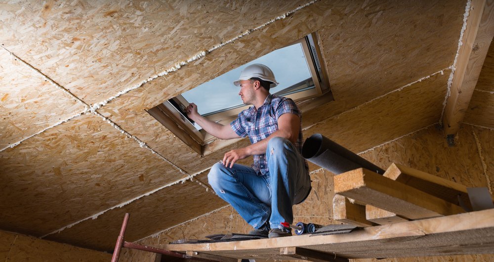 male construction worker builder crouching on elevated scaffolding near ceiling and inspecting