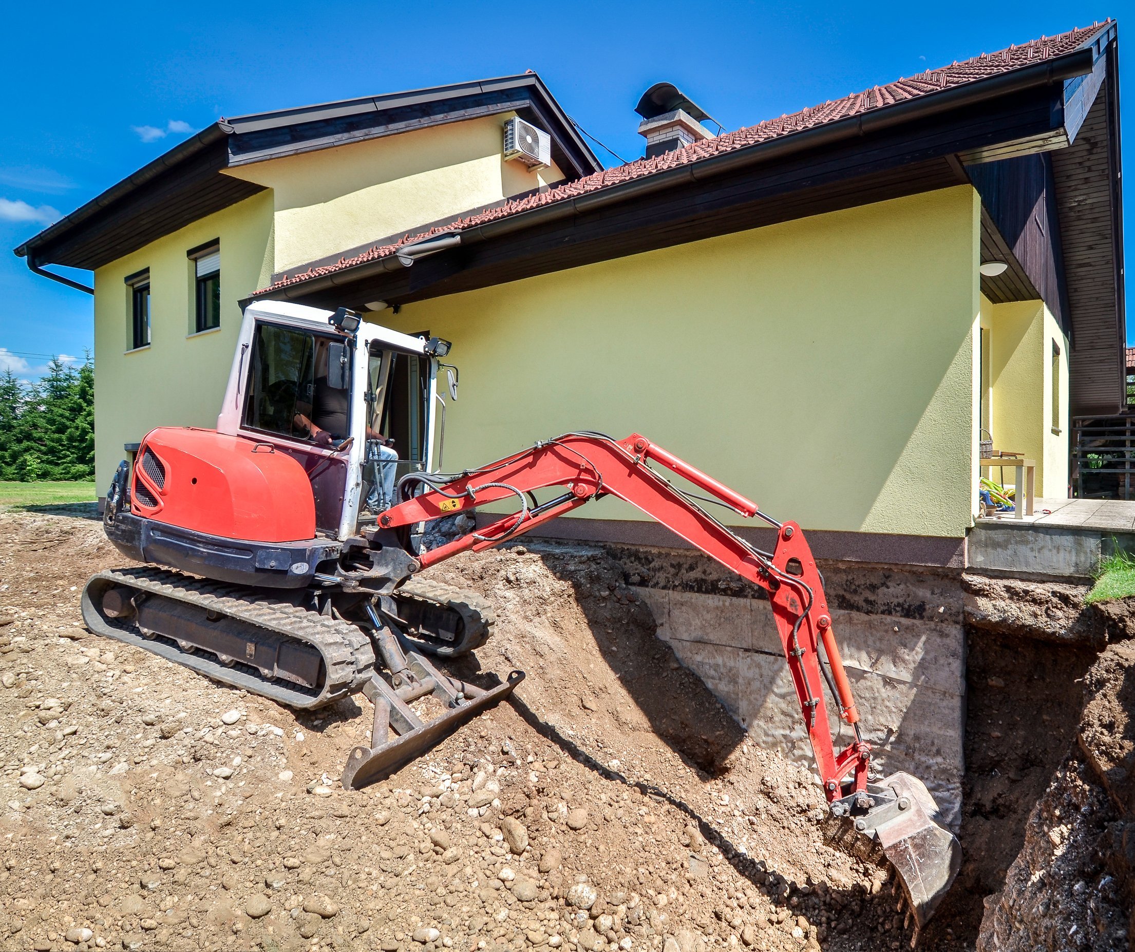 house is being rebuilt and renovated with the help of an excavator
