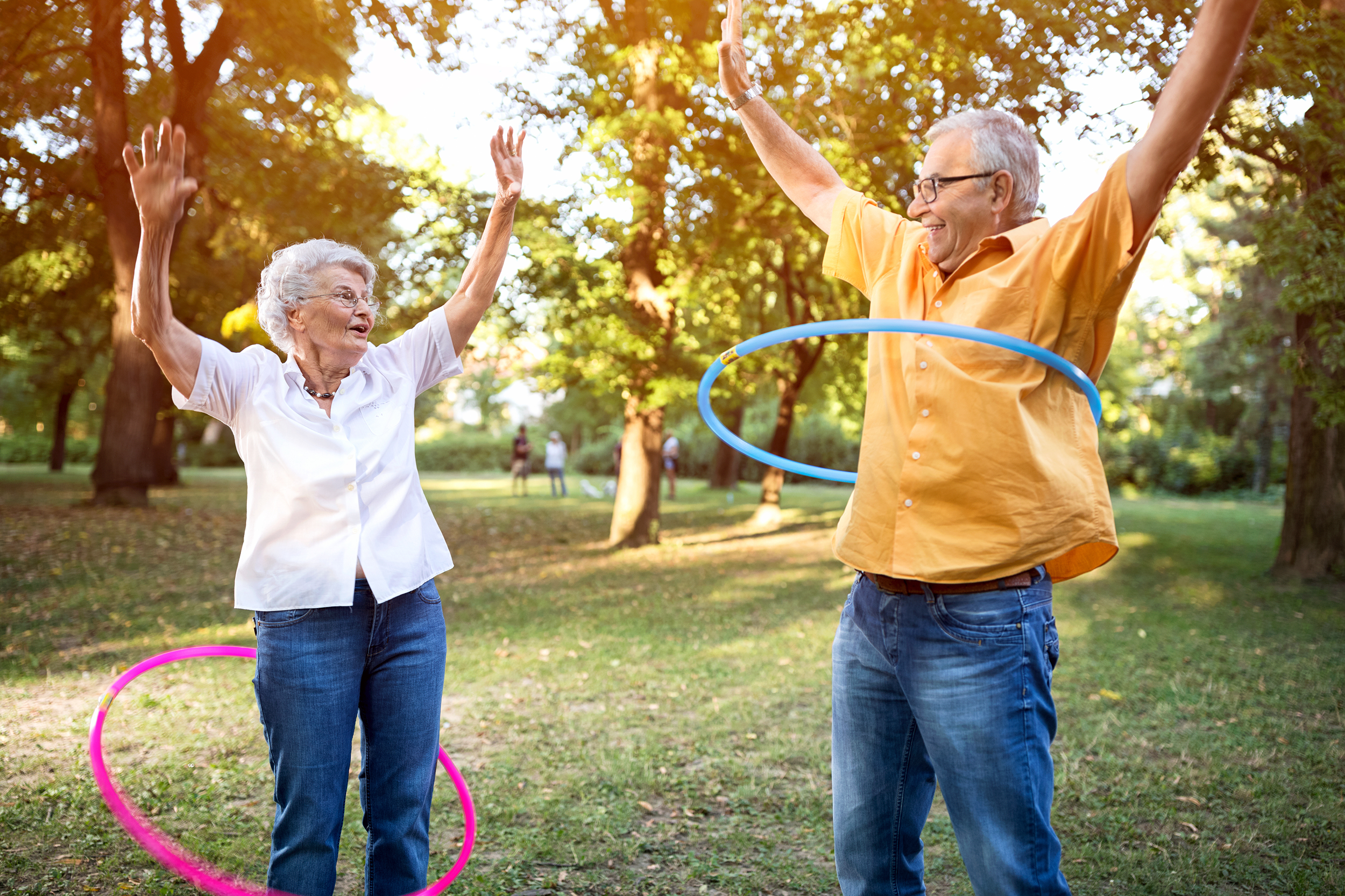Senior couple hula hooping in the park