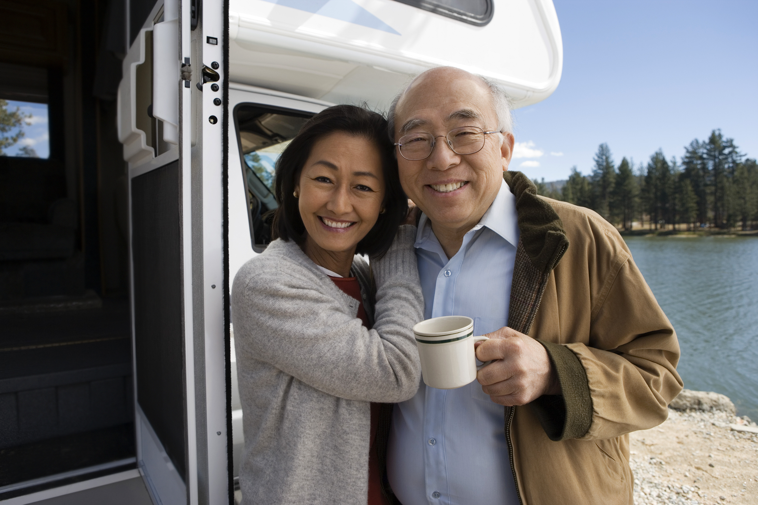 Senior couple standing outside of their RV