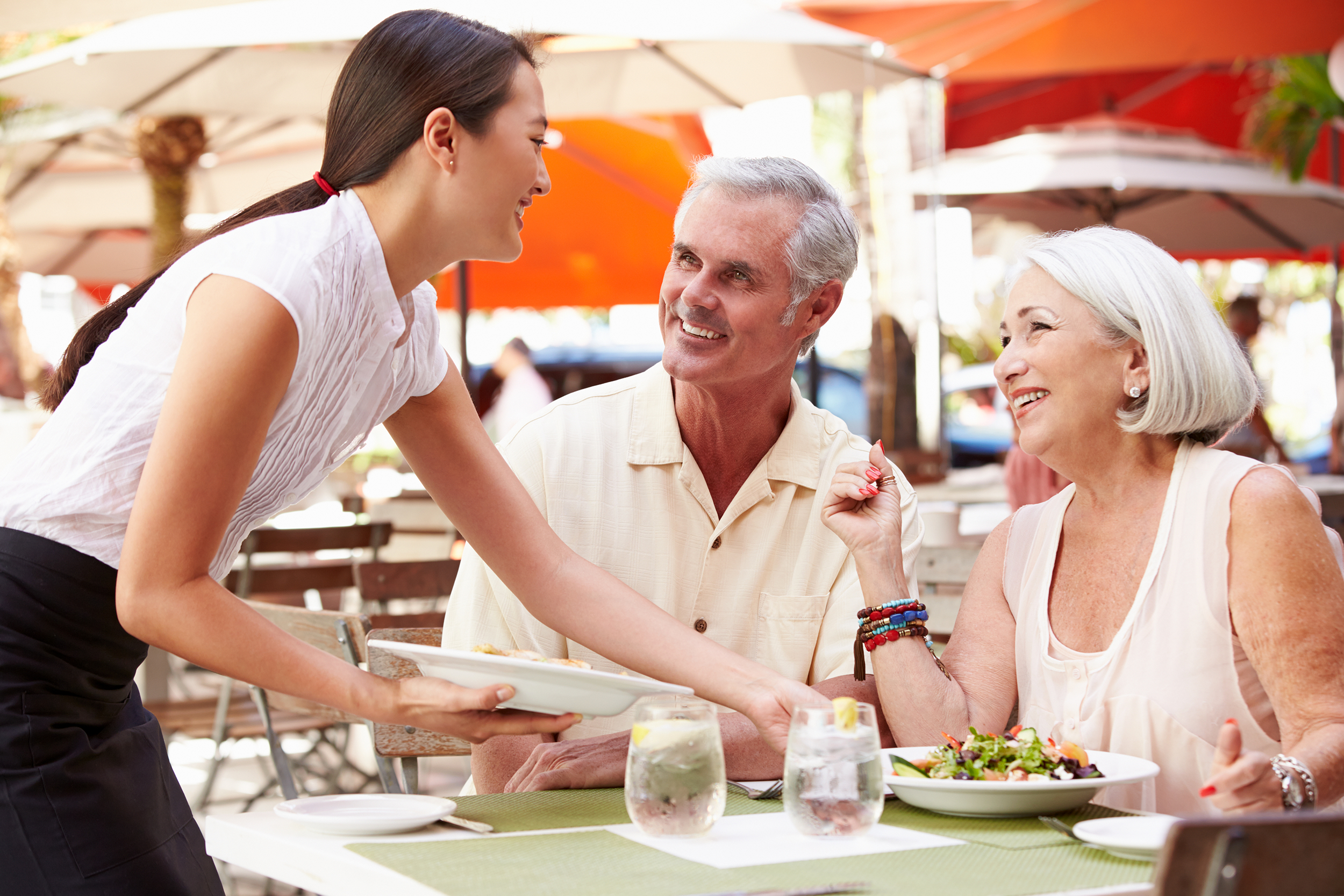 Senior couple eating on a restaurant patio