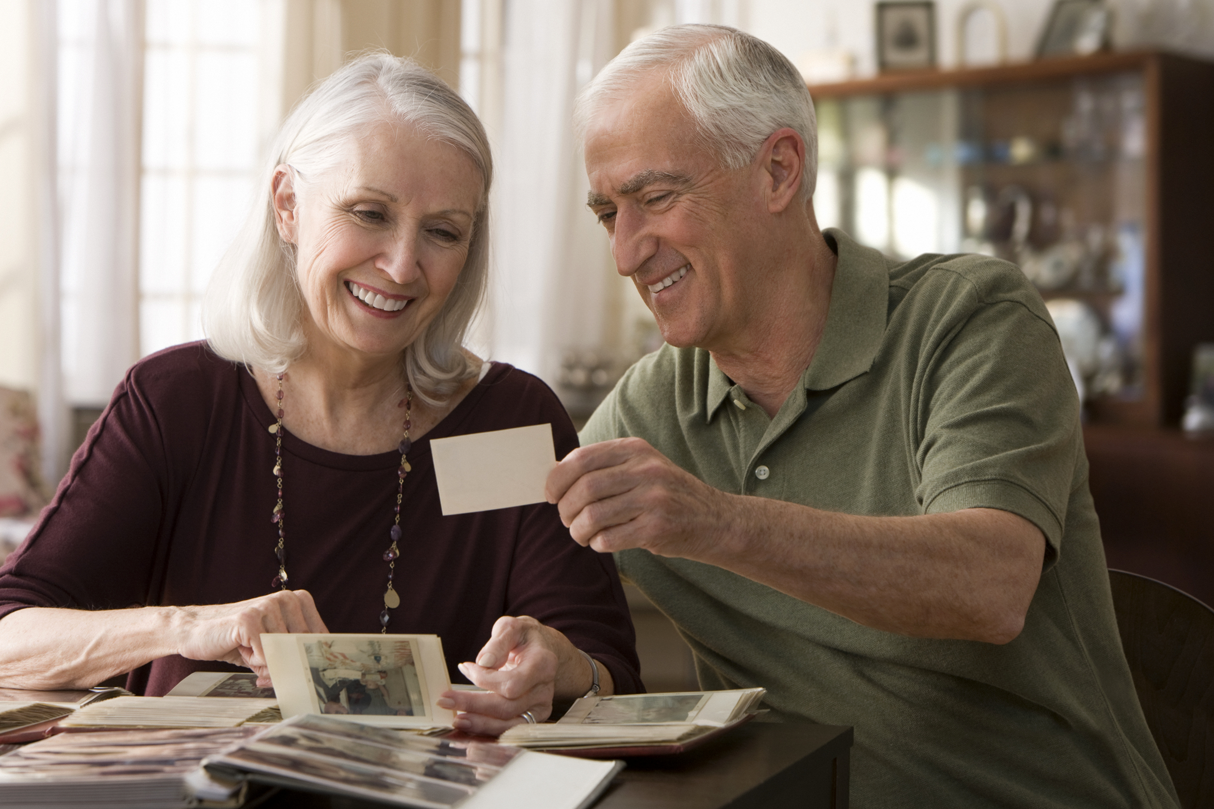 Senior couple looking through photo album and smiling