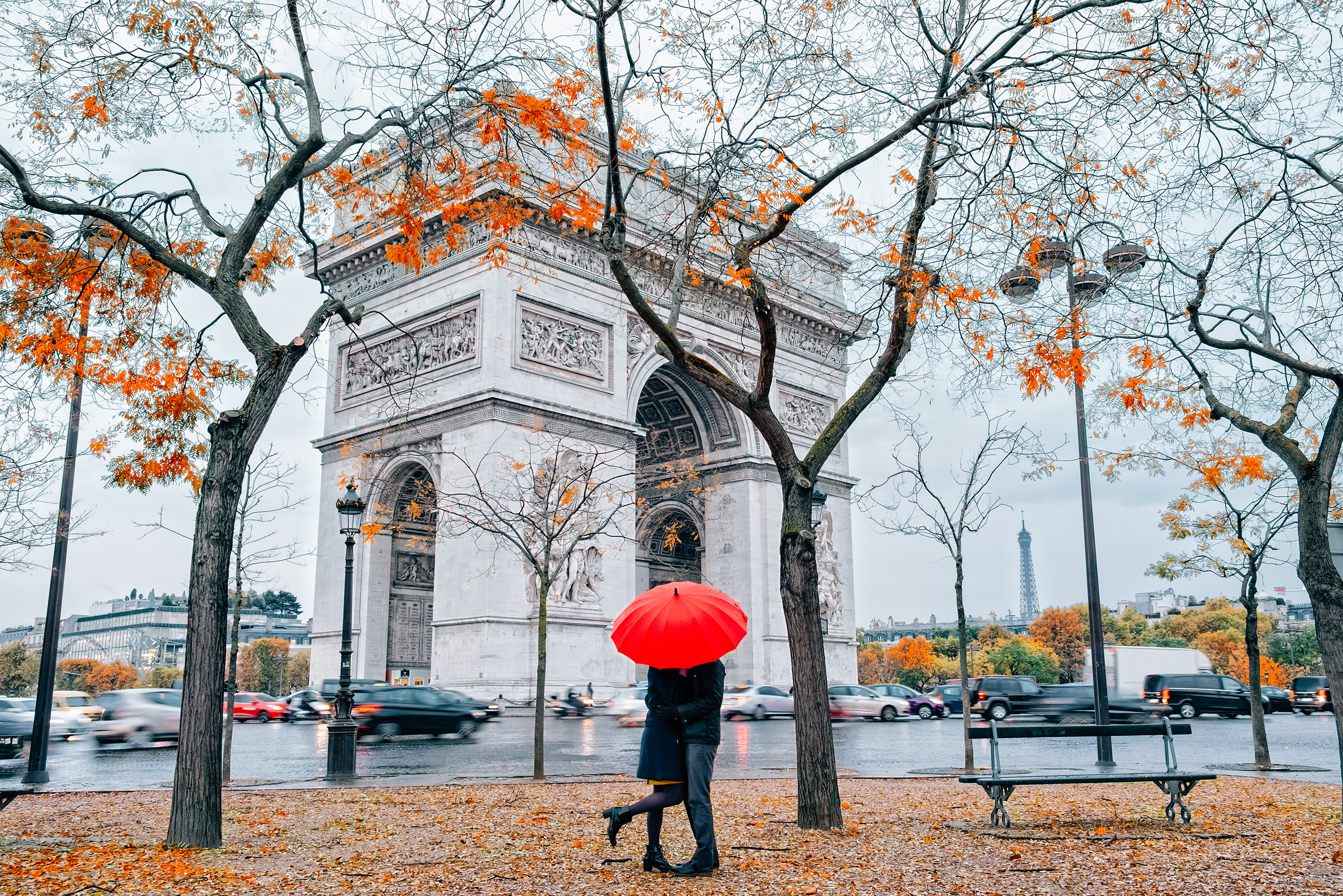 Couple standing under an umbrella in Paris in the fall