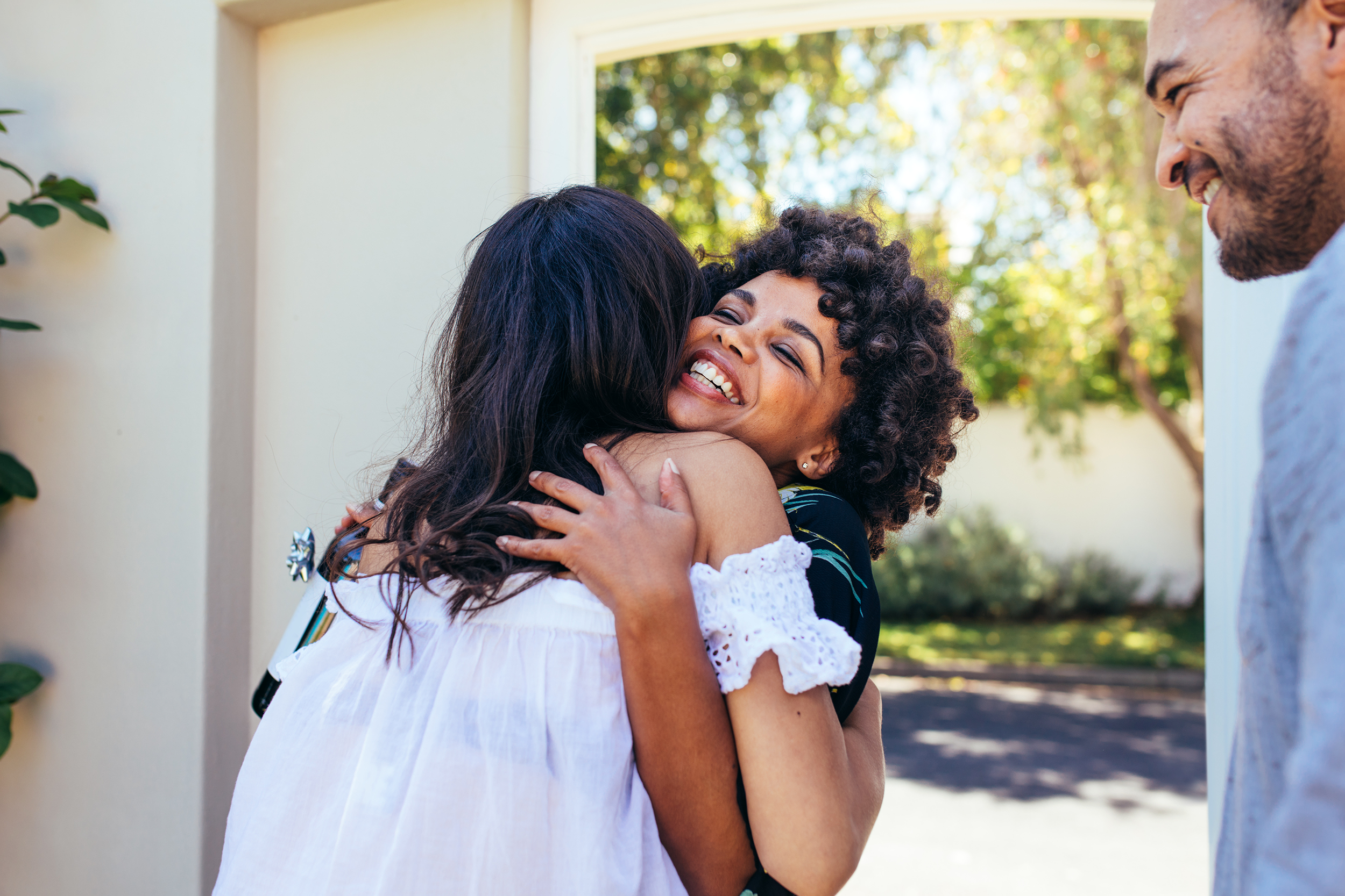 Friends giving guest a hug at the door