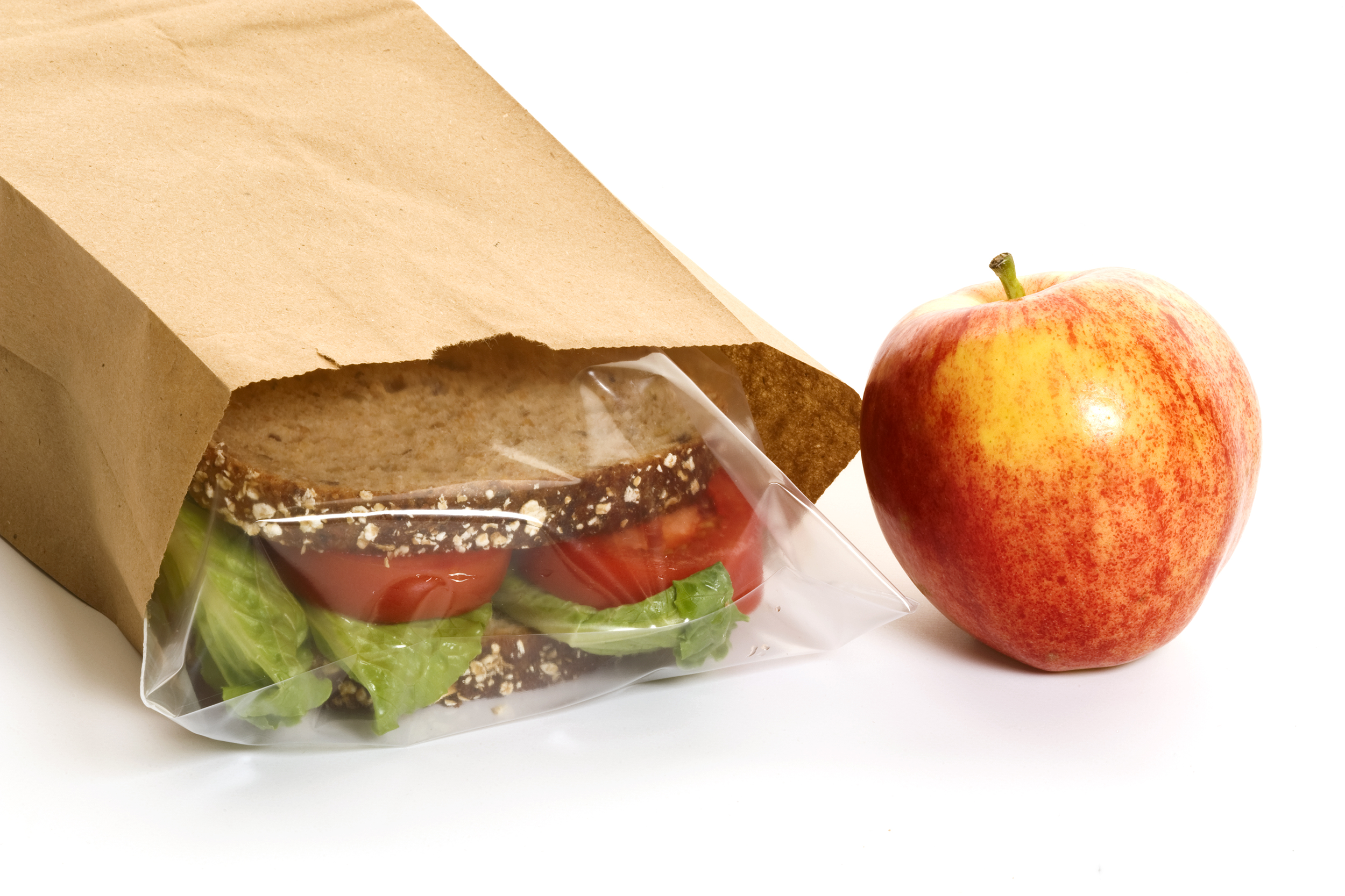 Brown paper bag lunch with sandwich and apple
