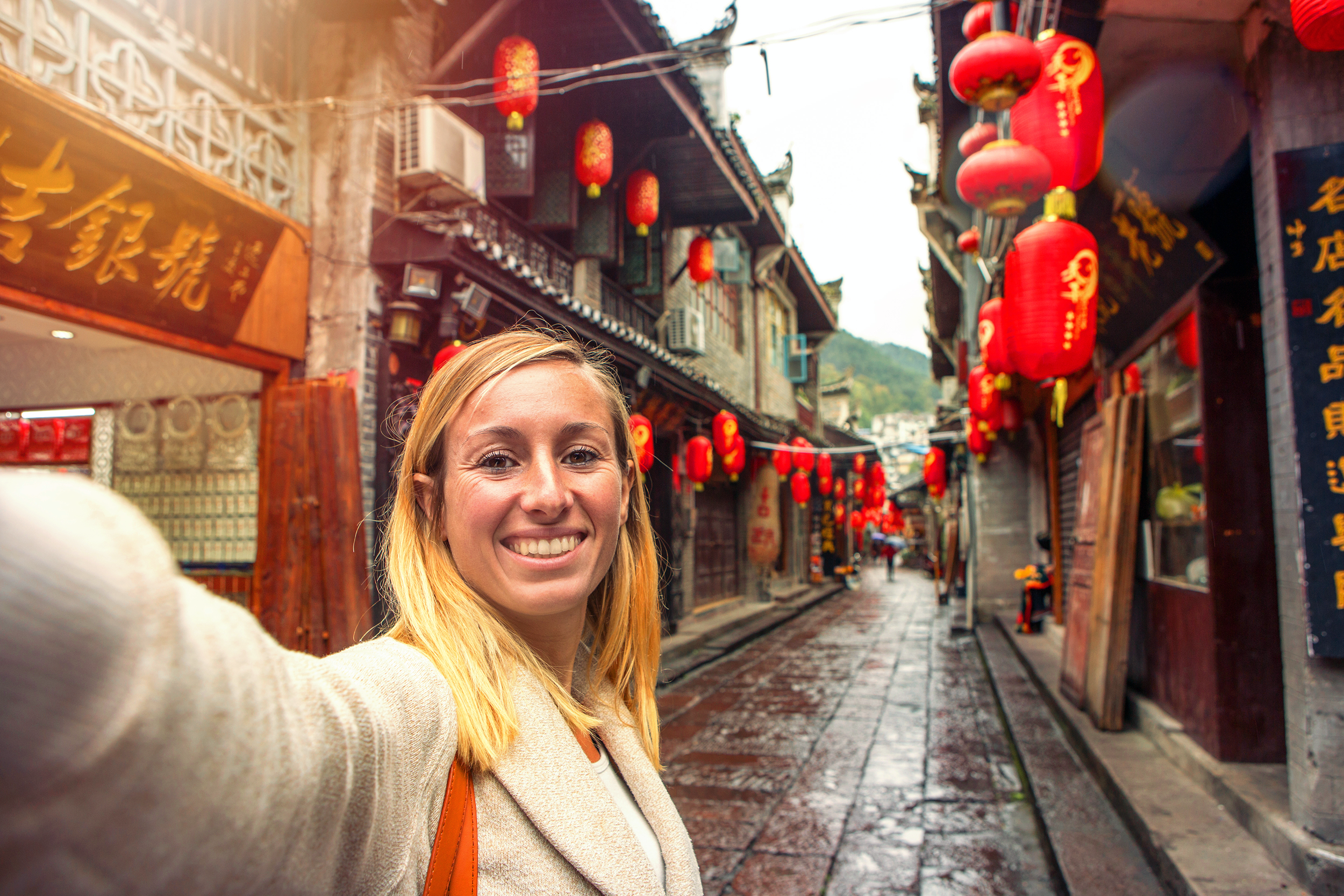 Woman taking a selfie on a street in an Asian city