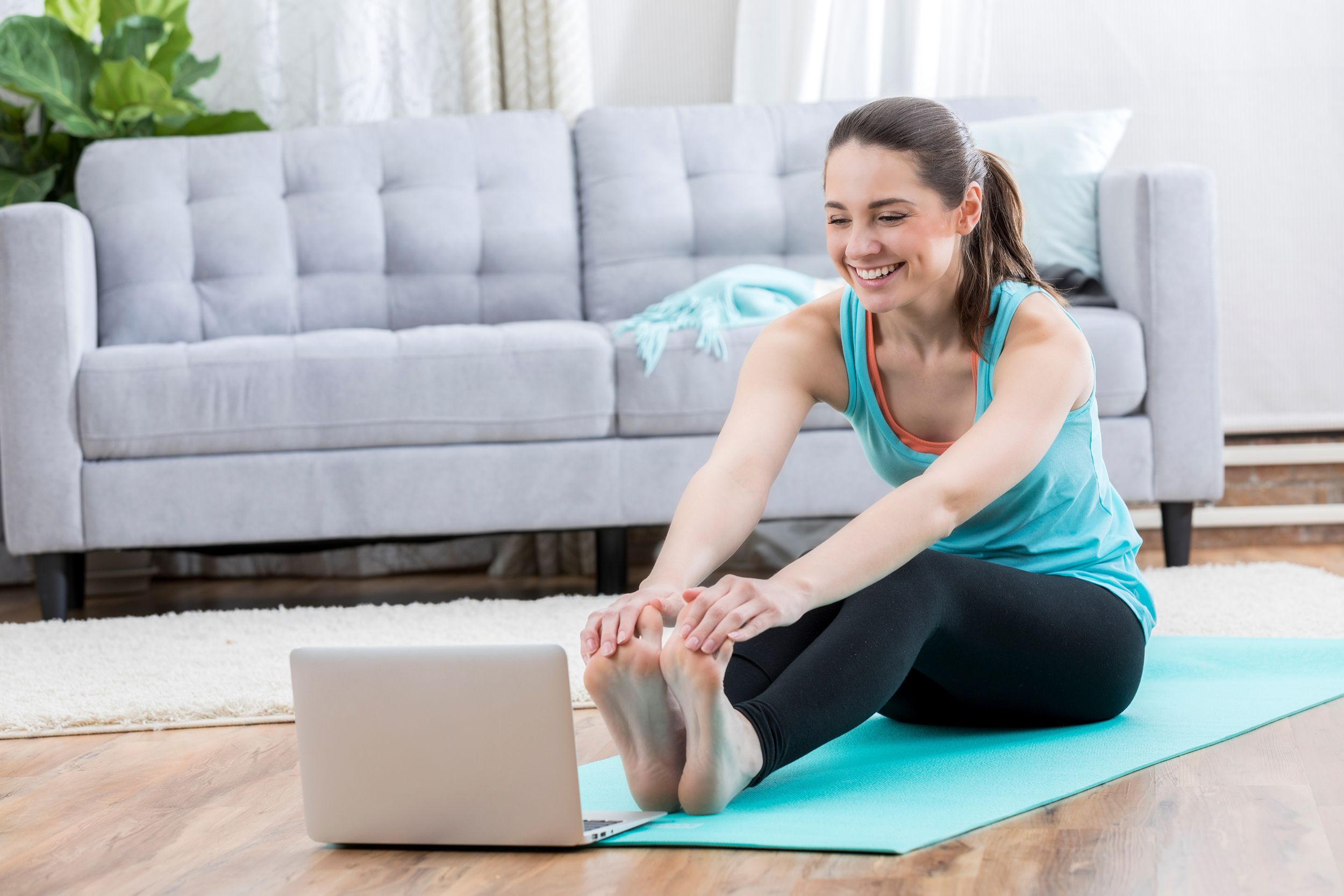 Woman watching an exercise video at home on her laptop