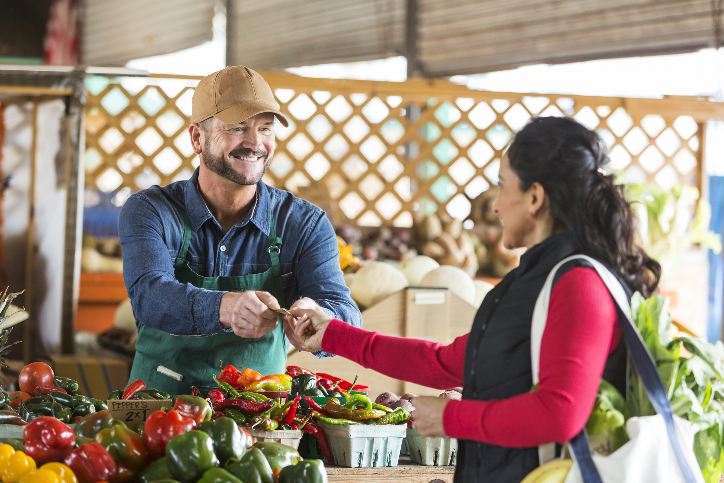 Woman talking to a local grocer at a farmer's market