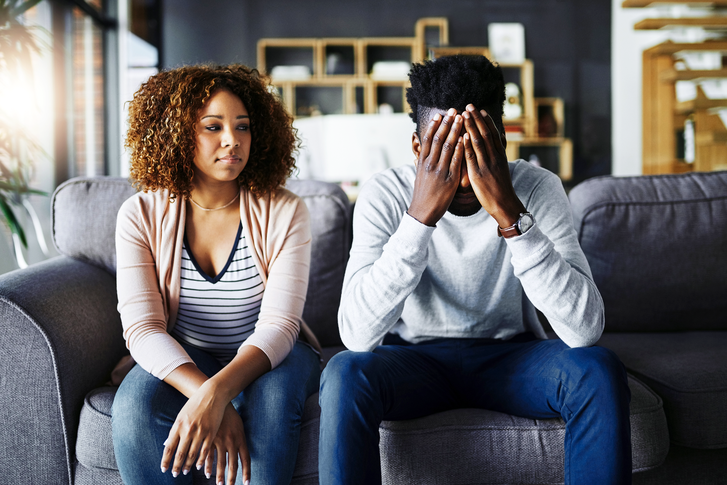 Couple unhappy sitting on the couch