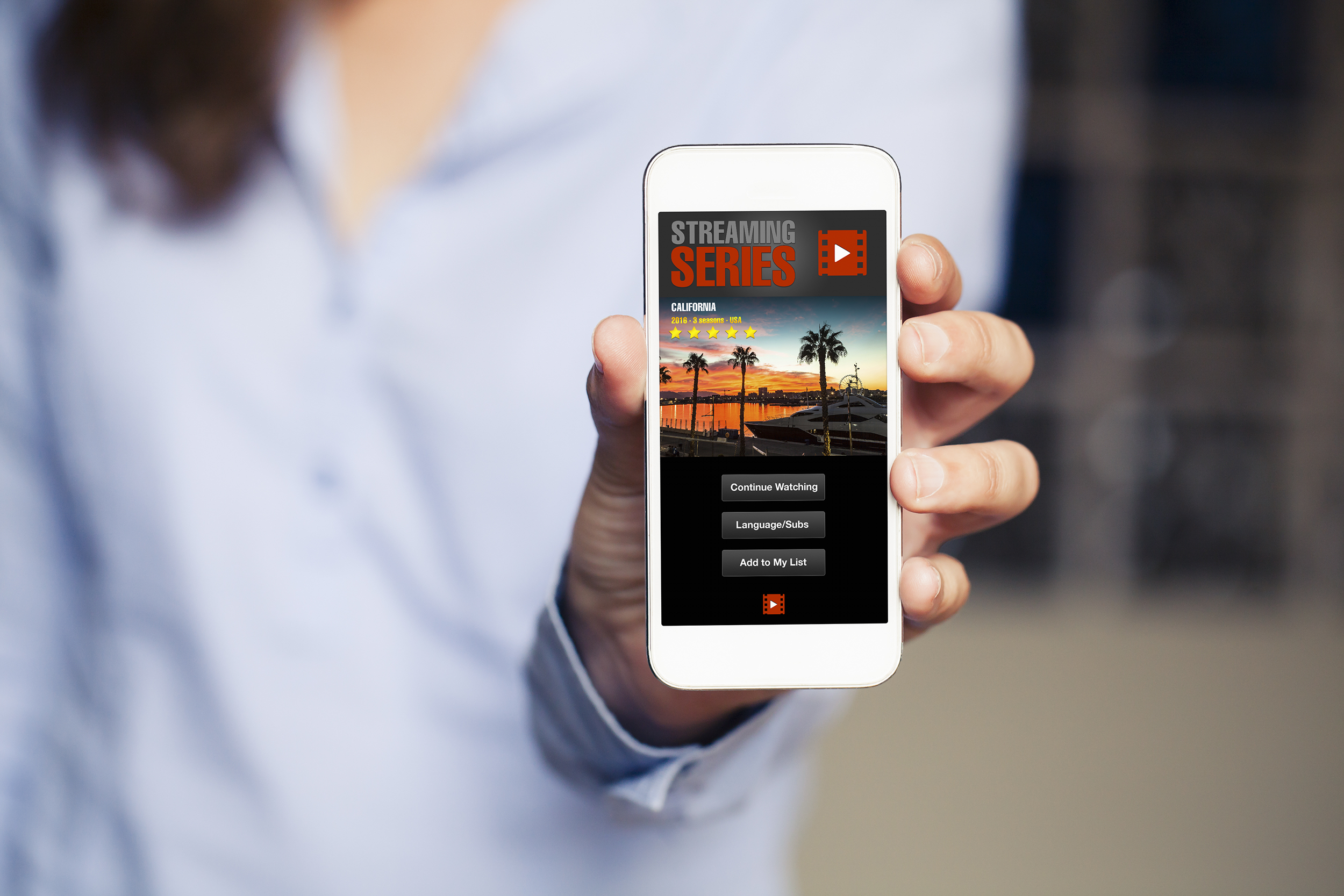 Woman holding smartphone with streaming service on the screen