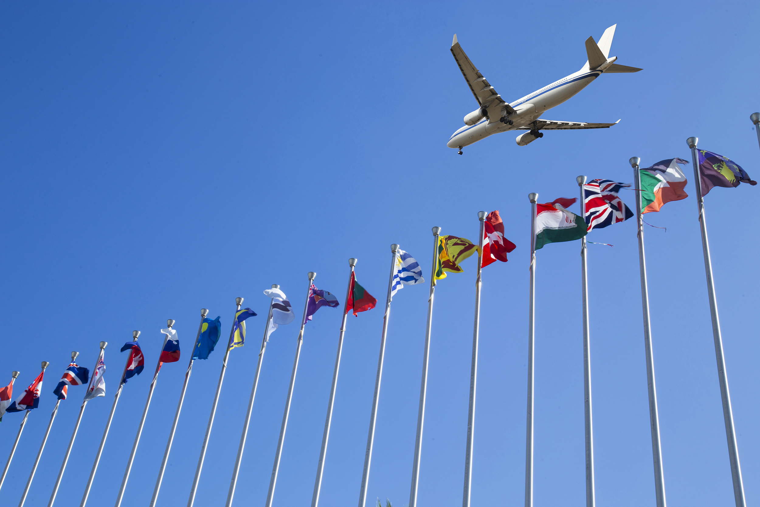 Plane flying over international flags