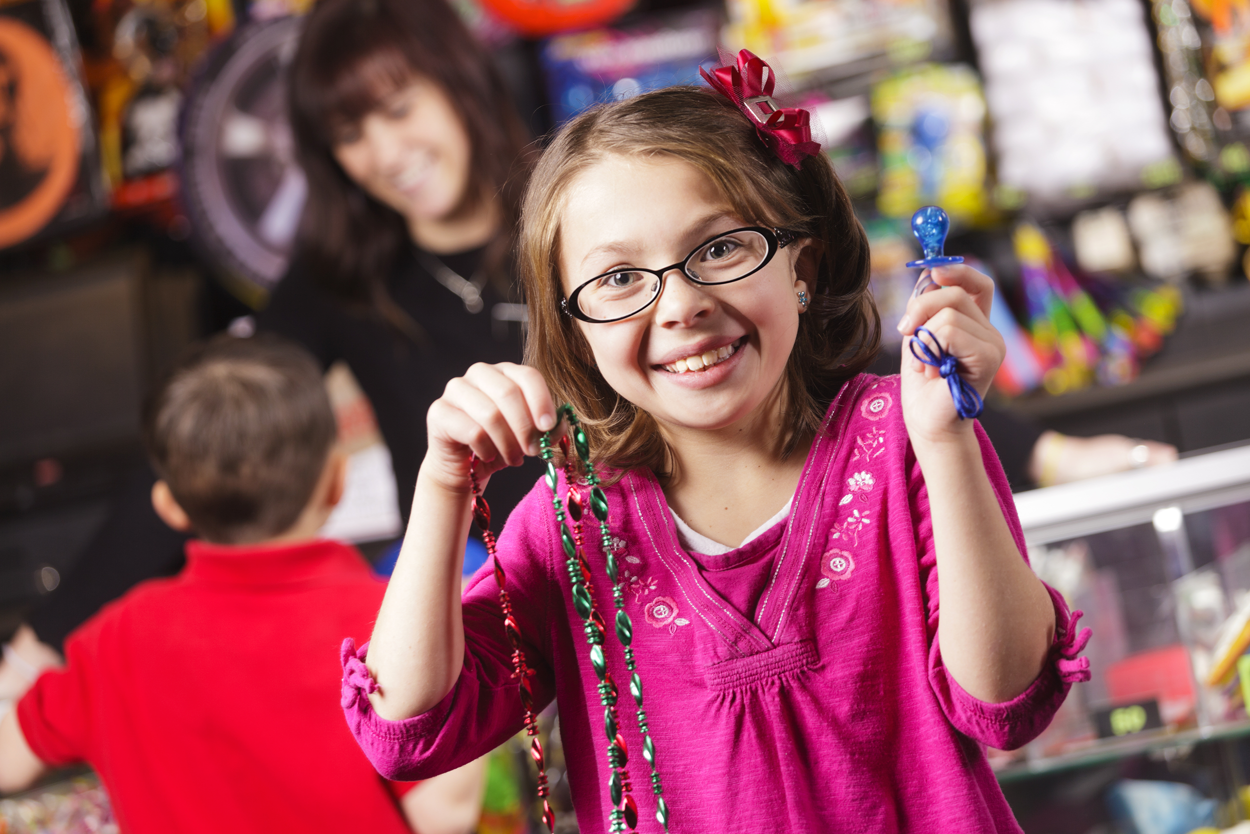 Girl holding up prizes in an arcade
