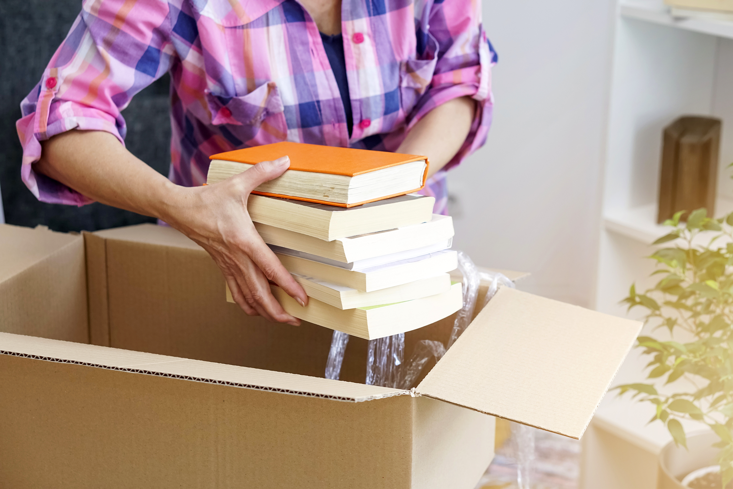 Packing up books into moving boxes